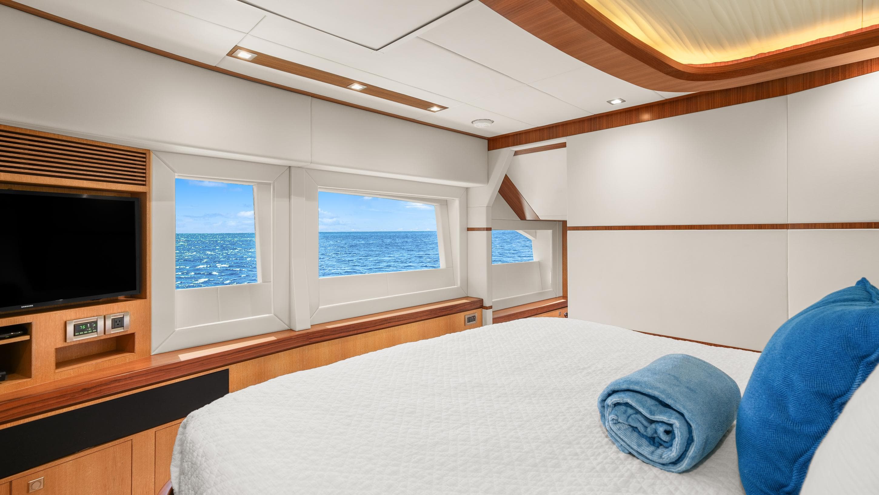 Luxurious Horizon PC74 yacht bedroom with ocean view, modern decor, and cozy bedding.