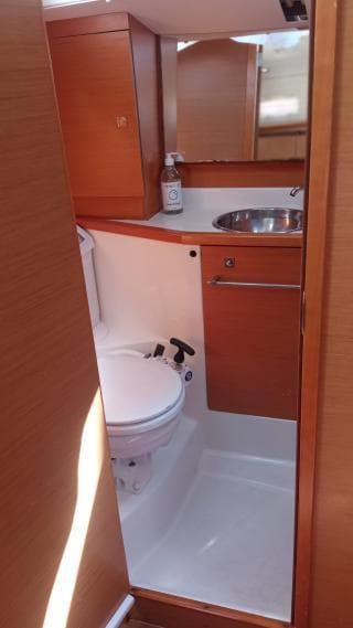 2012 Jeanneau Sun Odyssey 379 yacht bathroom with wooden cabinetry and compact design.