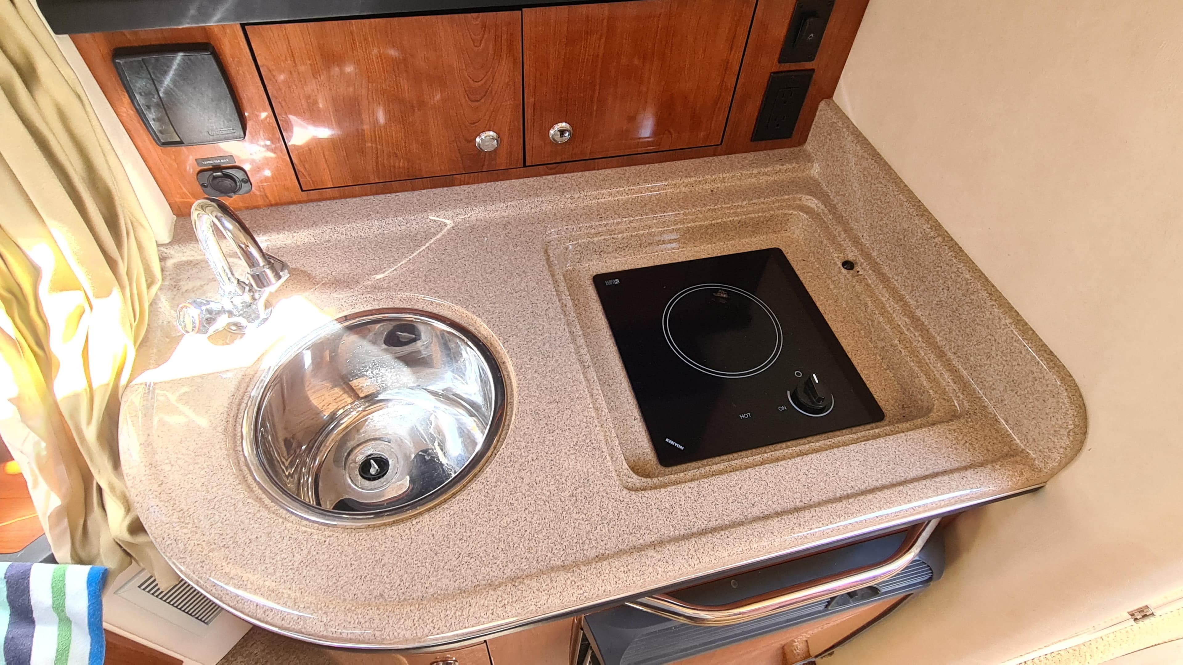 2007 Sea Ray 290 Sundancer galley with sink and stovetop.