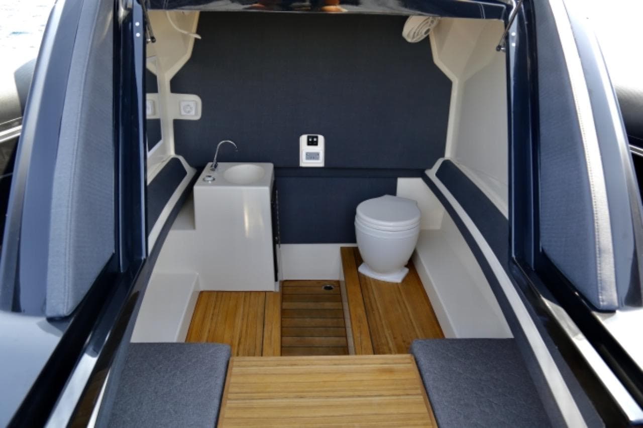 Interior of 2023 Technohull EXPLORER 40S boat, featuring a compact bathroom with wooden flooring.