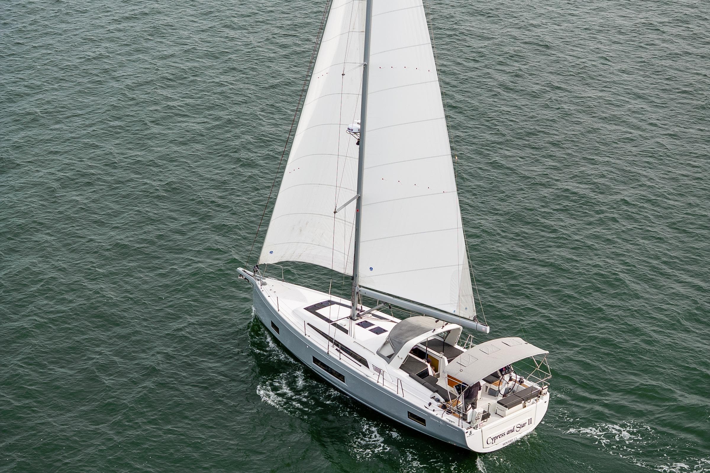 2020 Beneteau Oceanis 46.1 sailing on open water, aerial view.