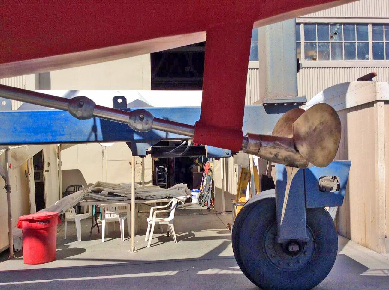 1989 Nonsuch 33 sailboat propeller and rudder in a boatyard setting.
