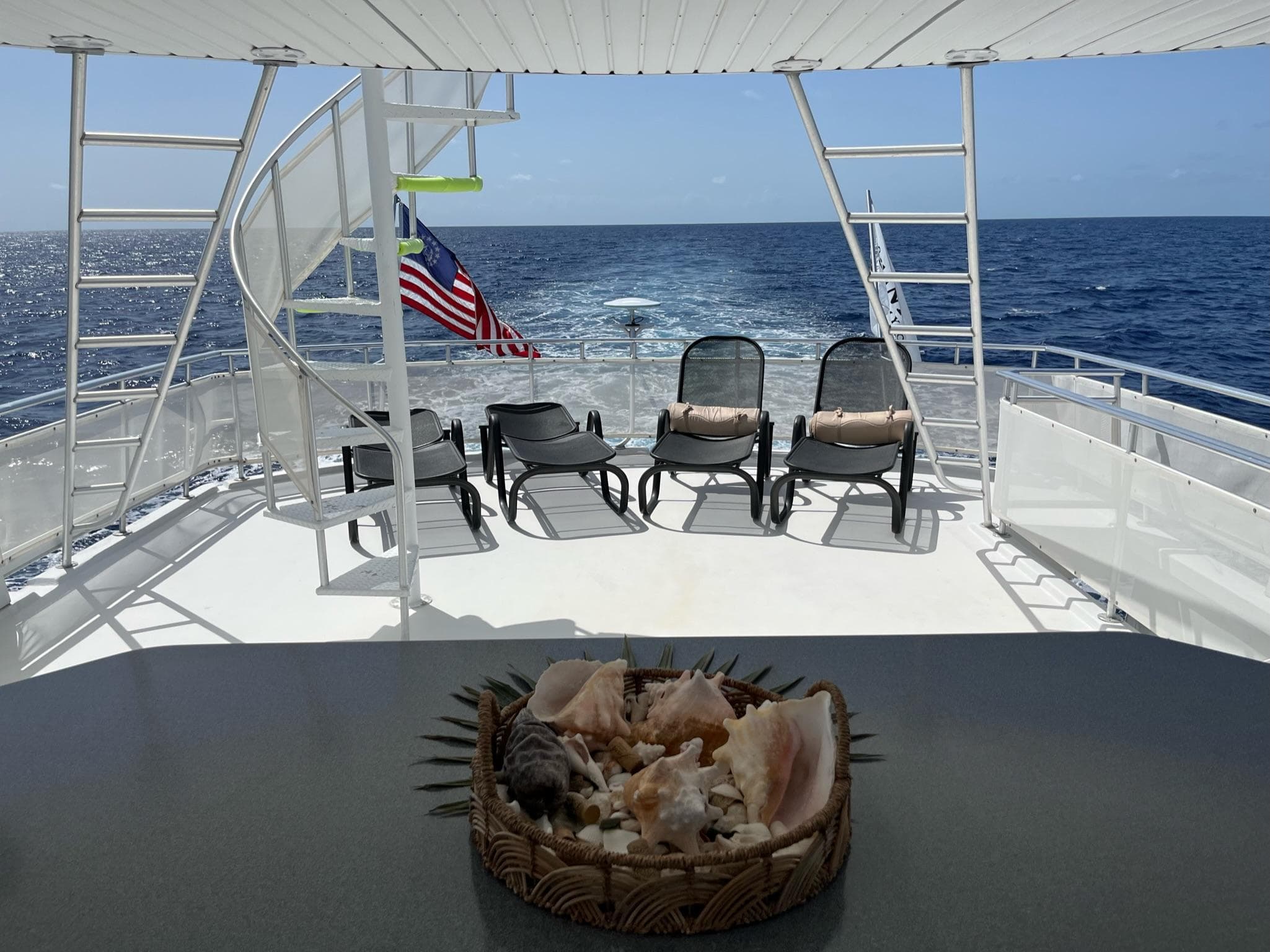 2009 Fantasy Houseboat deck with ocean view, lounge chairs, and seashell centerpiece.
