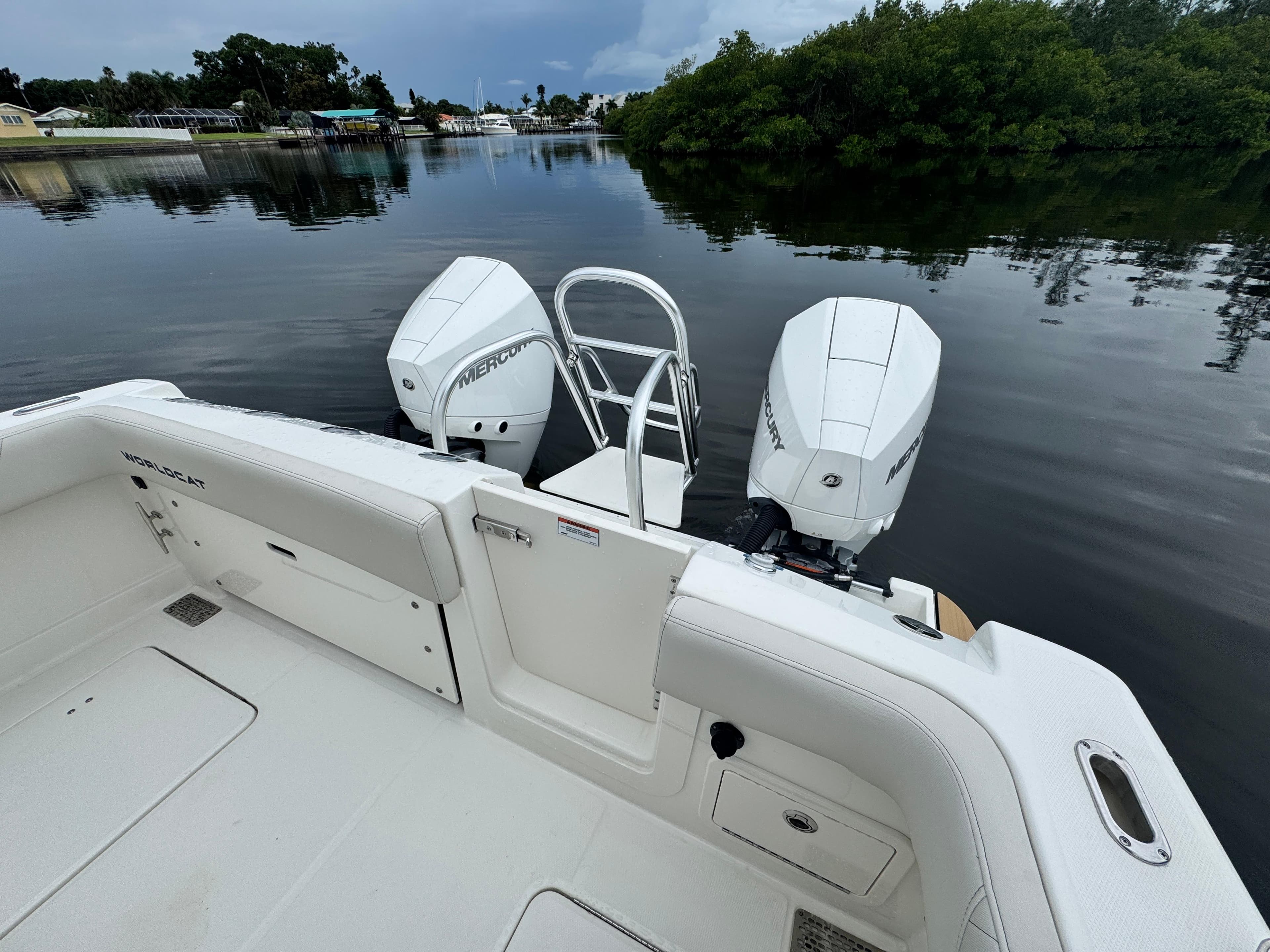 2025 World Cat 280 CC-X boat with dual Mercury engines on calm water.