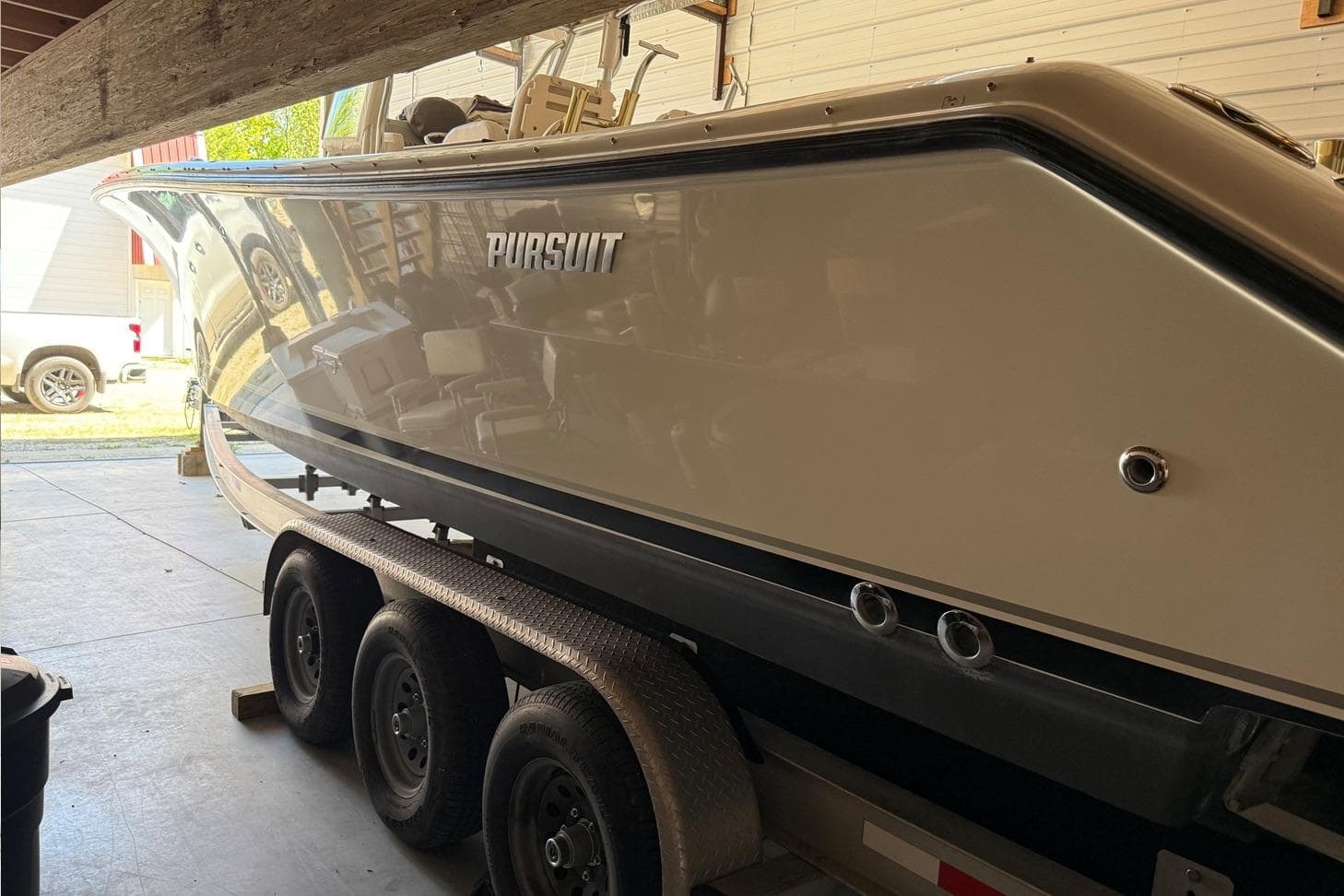 2007 Pursuit C 310 Center Console boat on trailer in garage.