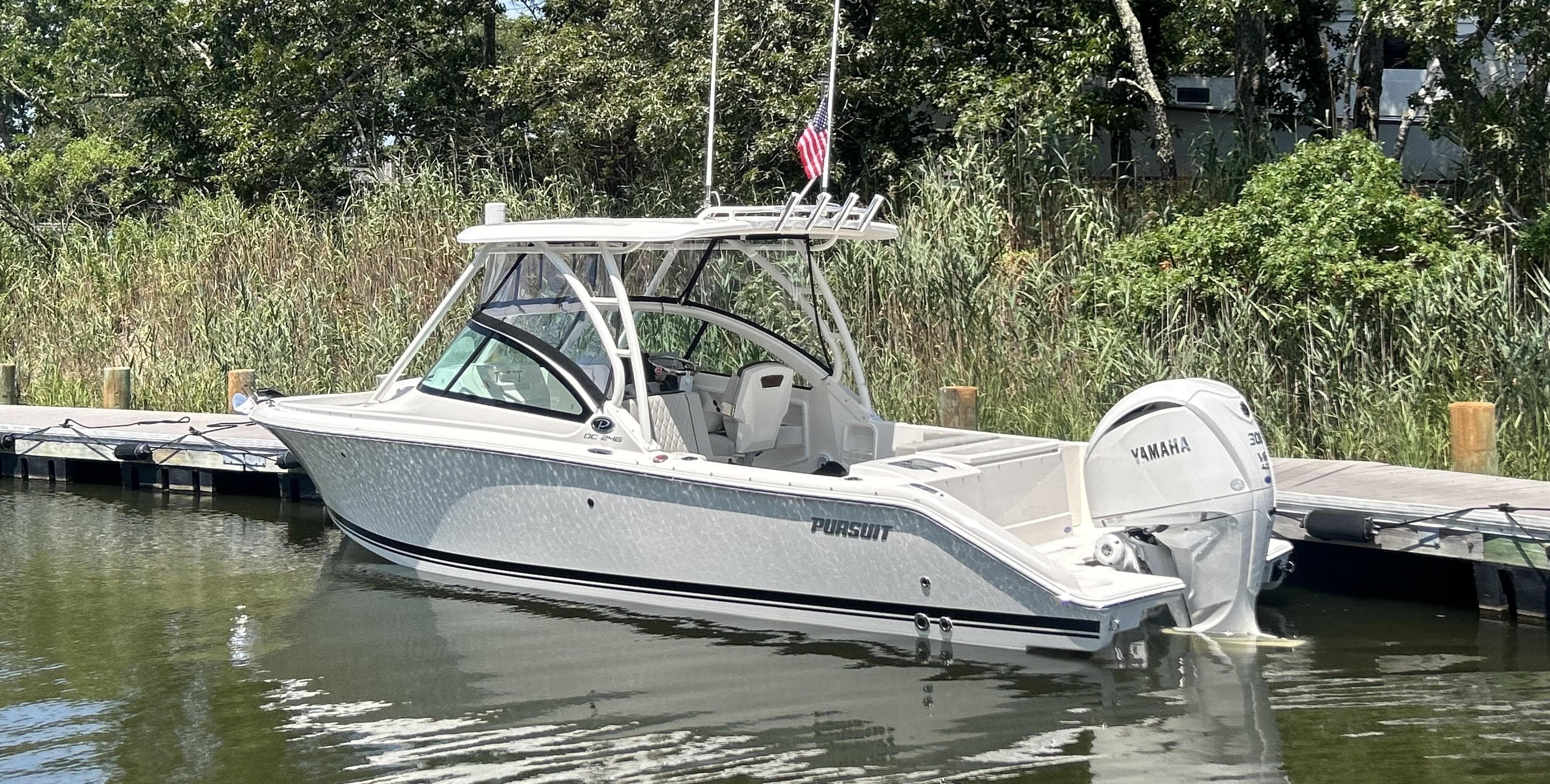 2026 Pursuit DC 246 Dual Console boat docked with Yamaha engine.