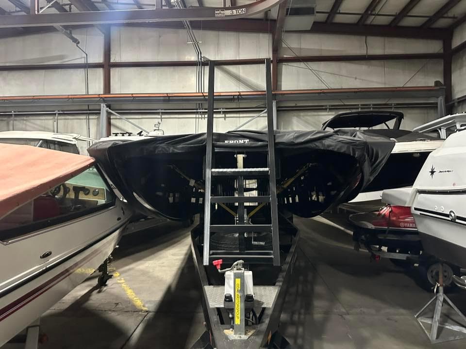 2018 MTI 340X boat stored indoors, covered, with ladder access.