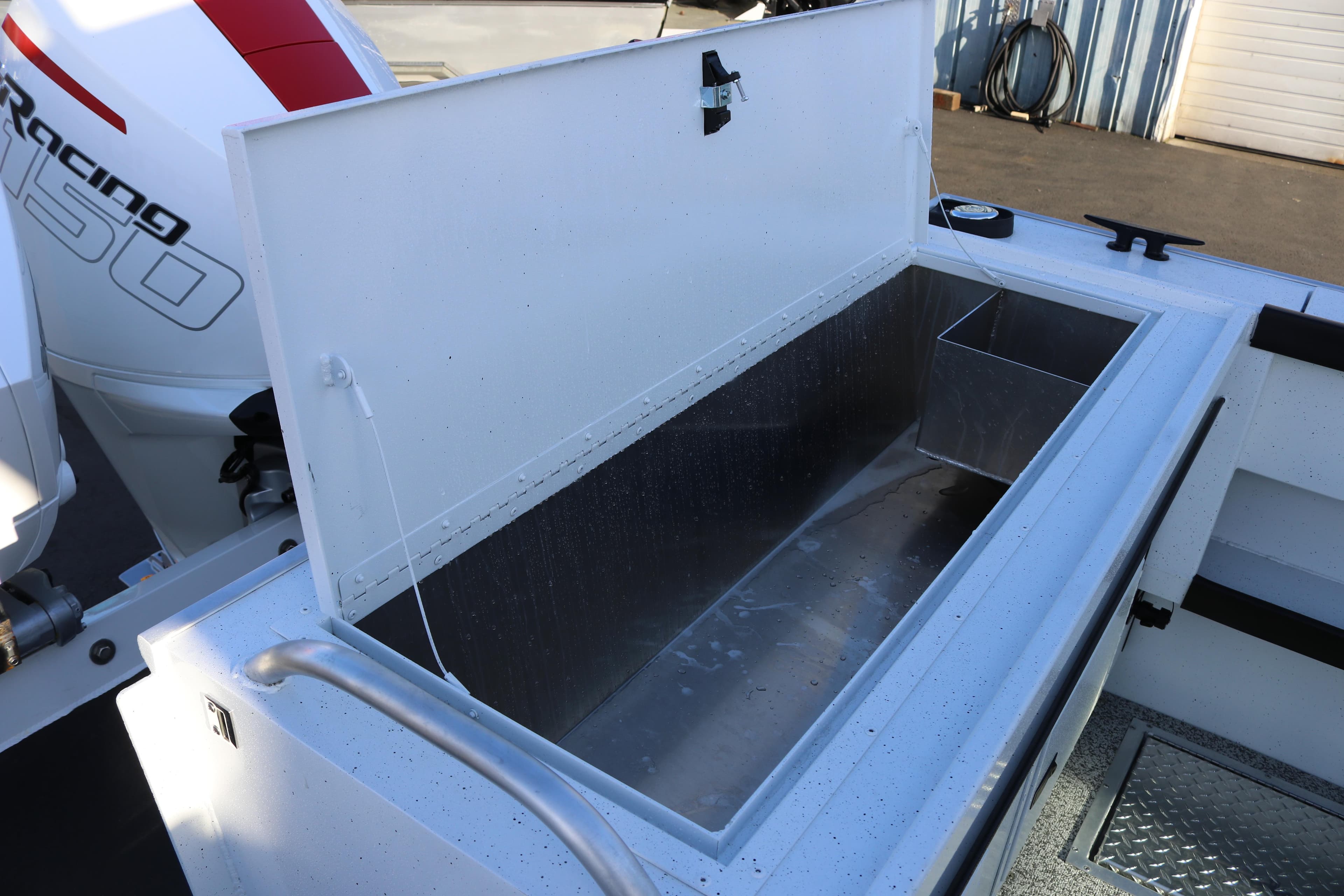 Open storage compartment on 2026 Alumaweld Horizon 26 boat, featuring a powerful engine.