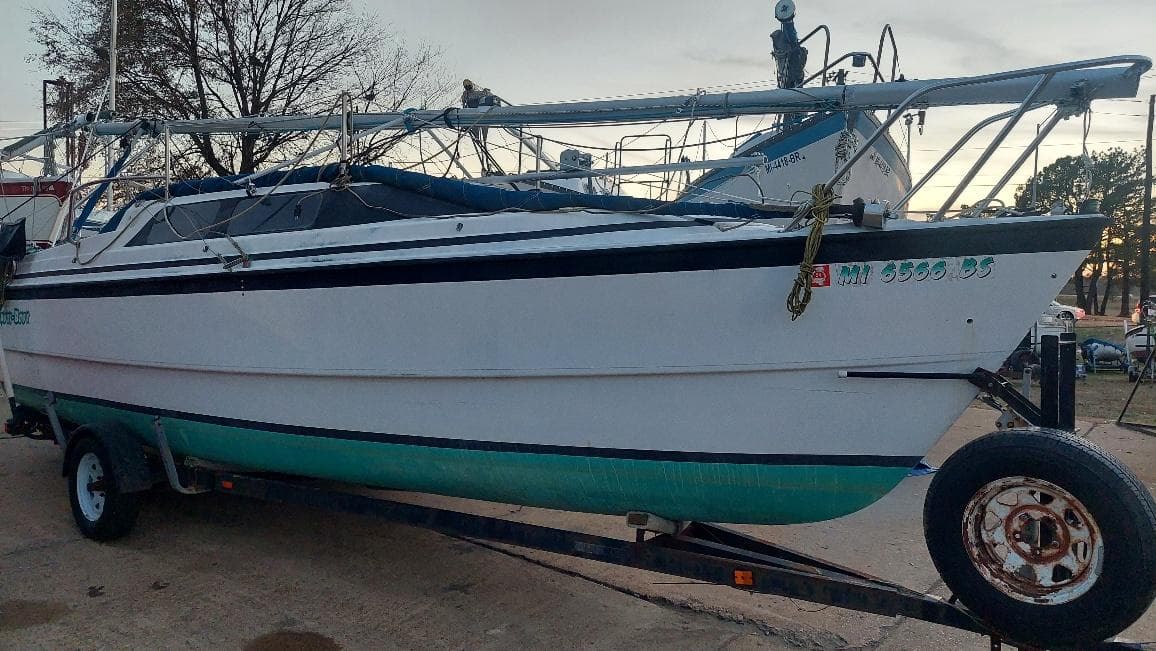 1996 MacGregor 26 "X" sailboat on trailer, parked outdoors.