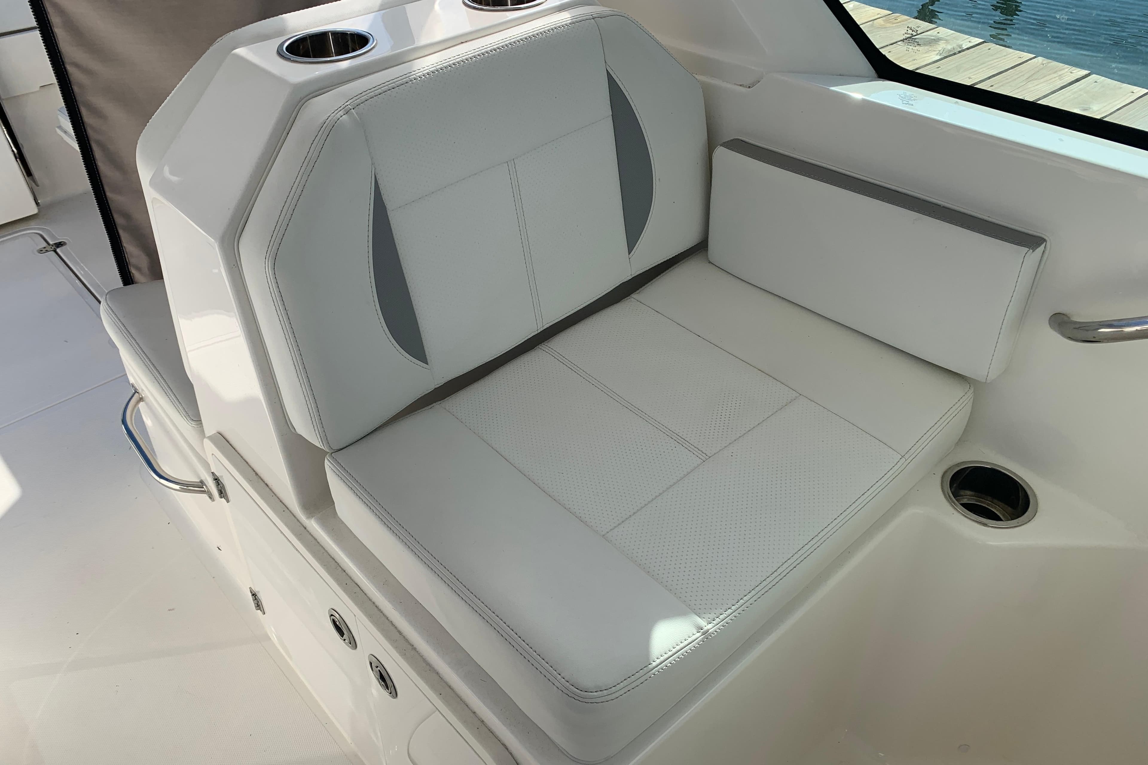 2023 Pursuit DC 266 Dual Console boat seat with cup holders and white upholstery.