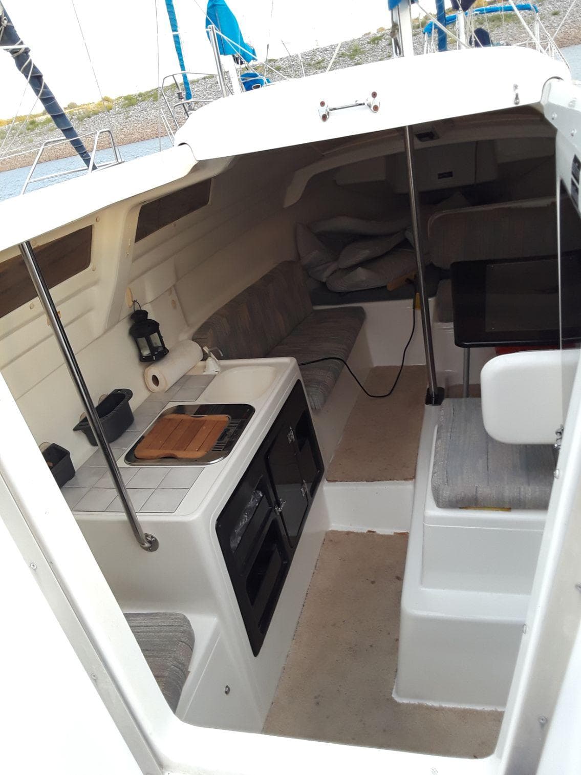 Interior of 1996 MacGregor 26 "X" sailboat with compact kitchen and seating area.