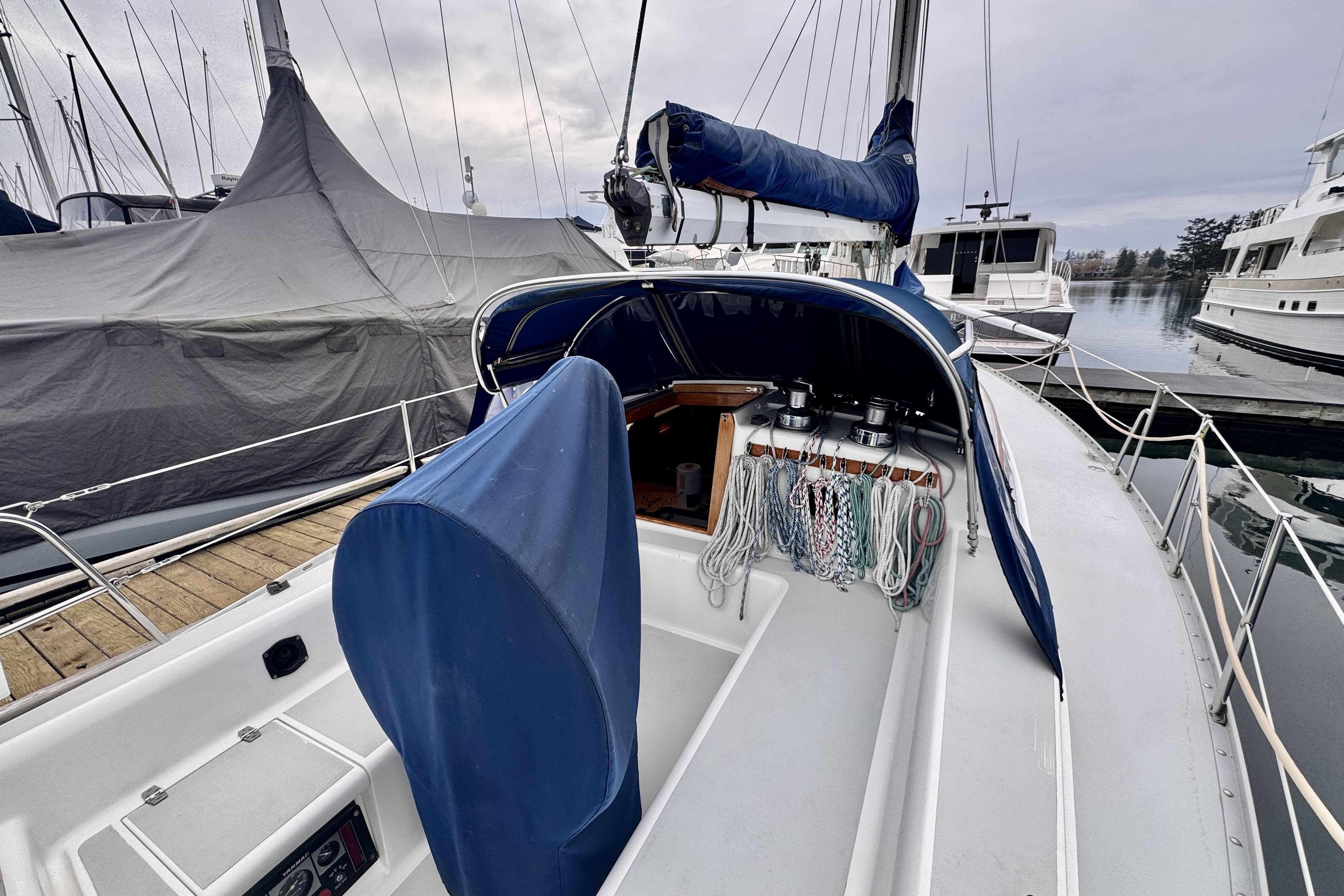 1991 Freedom 38 sailboat with blue covers docked at marina, showcasing deck and rigging.