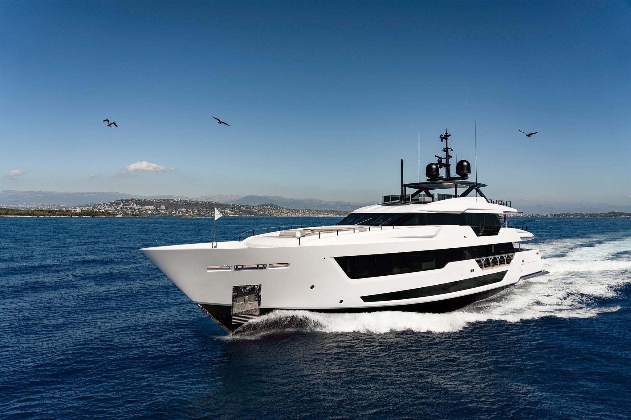 Luxurious 2022 Custom Line CL 140 yacht cruising on open sea under clear blue sky.