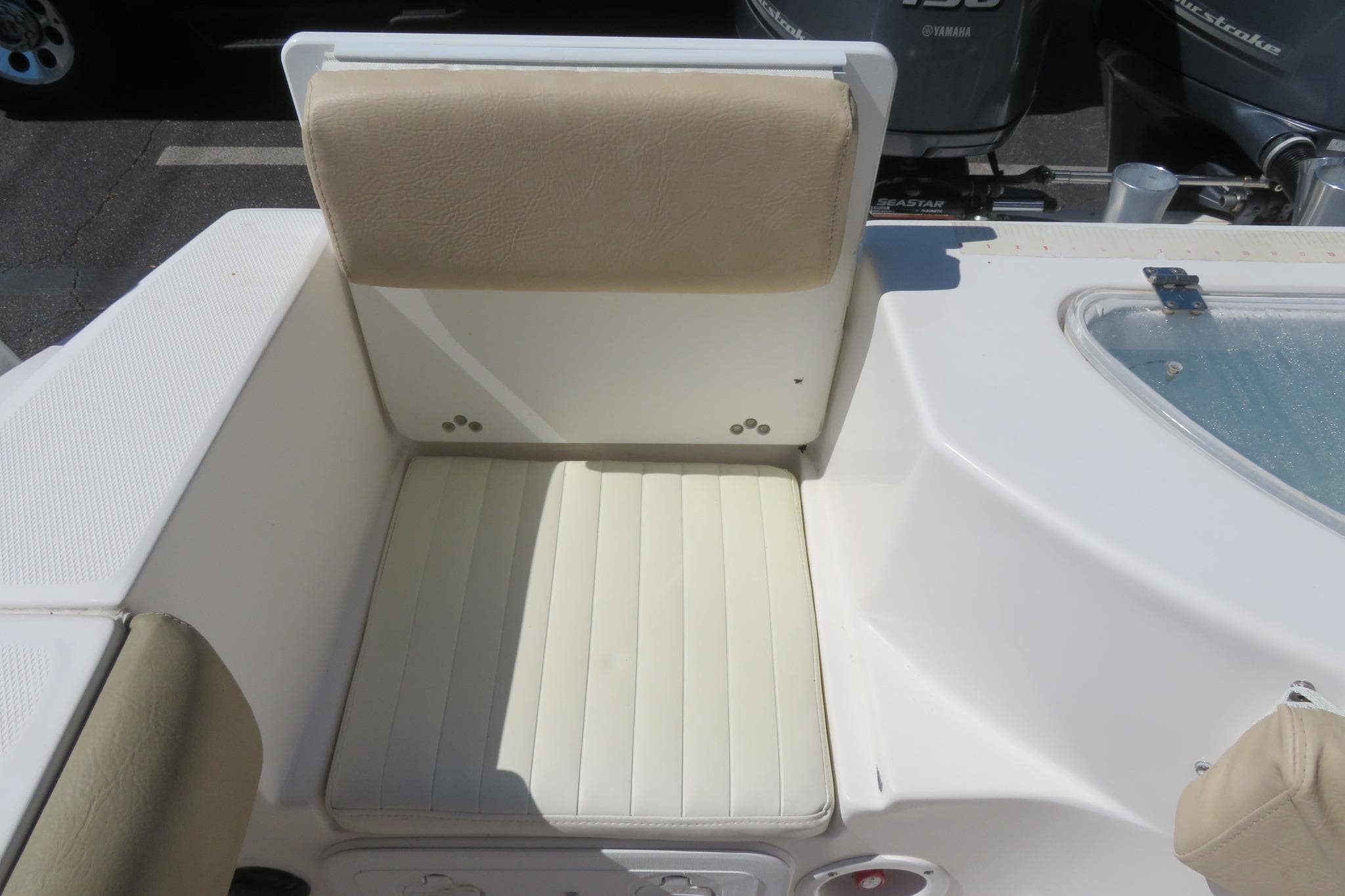 2017 Sea Fox 256 Voyager boat seat with beige upholstery and storage compartment.