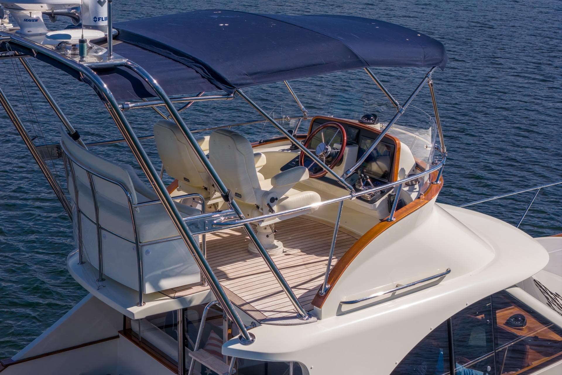 Flybridge of 2010 San Juan SJ40FB IPS yacht with blue canopy on water.
