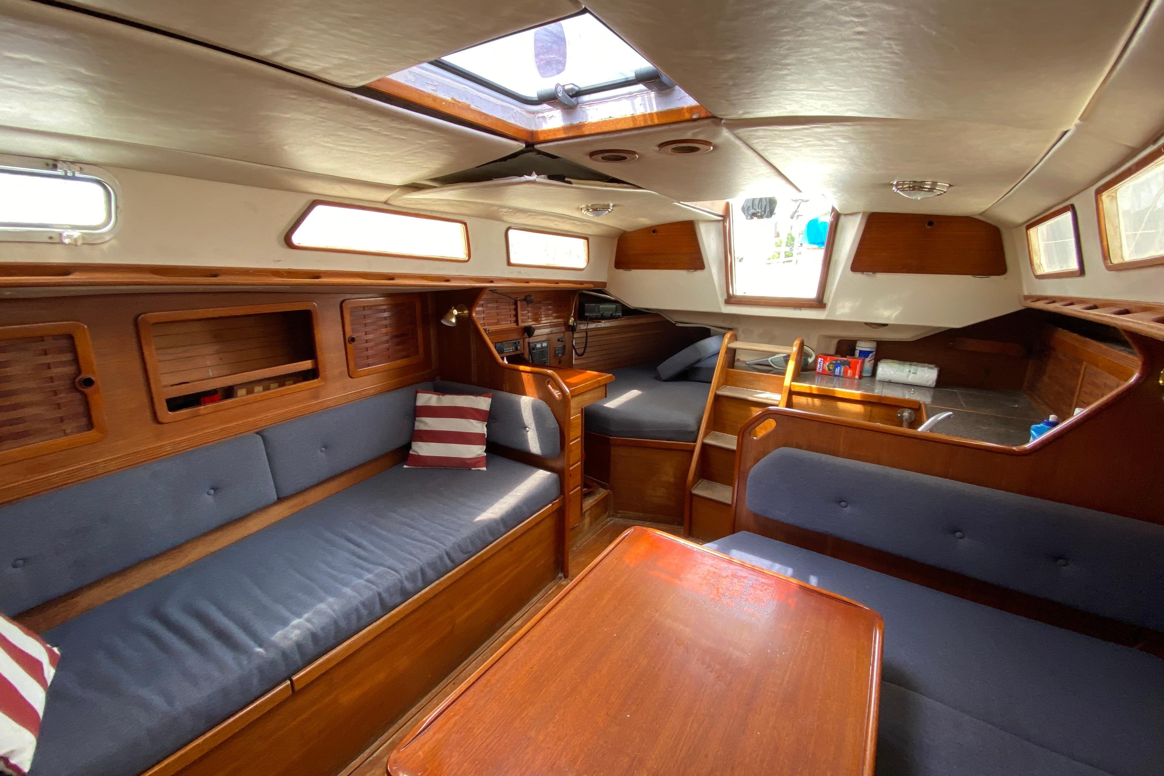 Interior of 1986 Sabre 36 sailboat with wooden finish and blue seating.