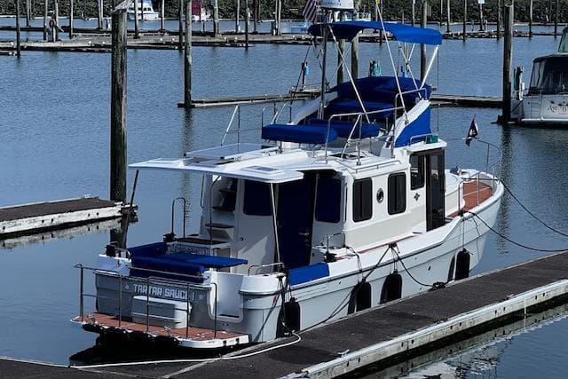 2021 Ranger Tugs R-31 CB docked in a marina, featuring blue accents and spacious deck.
