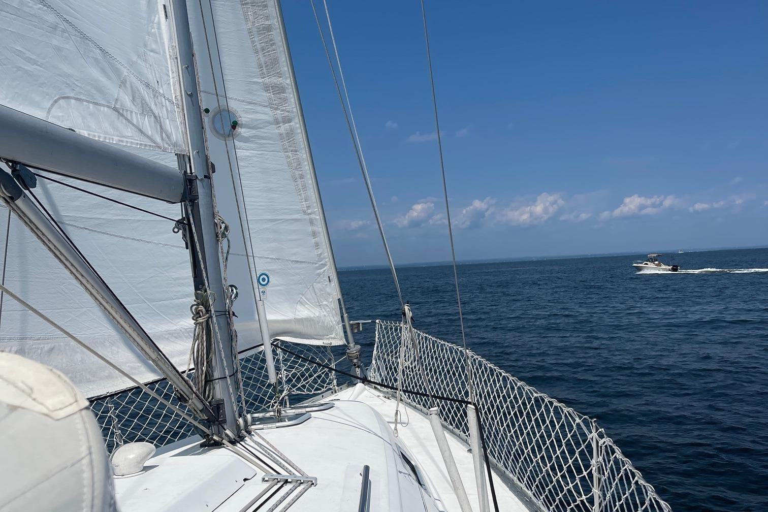 Sailing on a 2000 Beneteau 331 yacht with clear blue skies and ocean view.