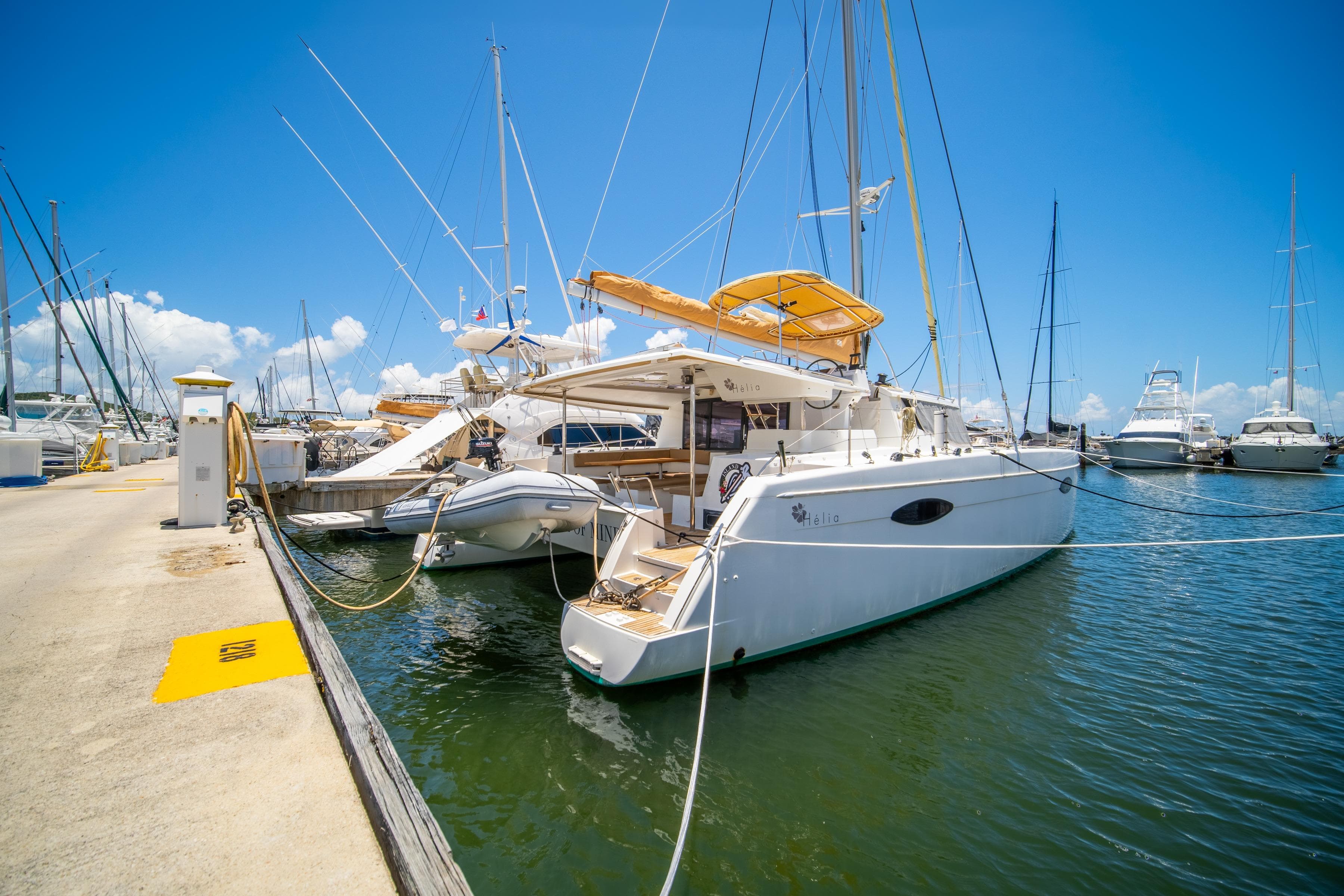 2014 Fountaine Pajot Helia 44 catamaran docked at marina under clear blue sky.
