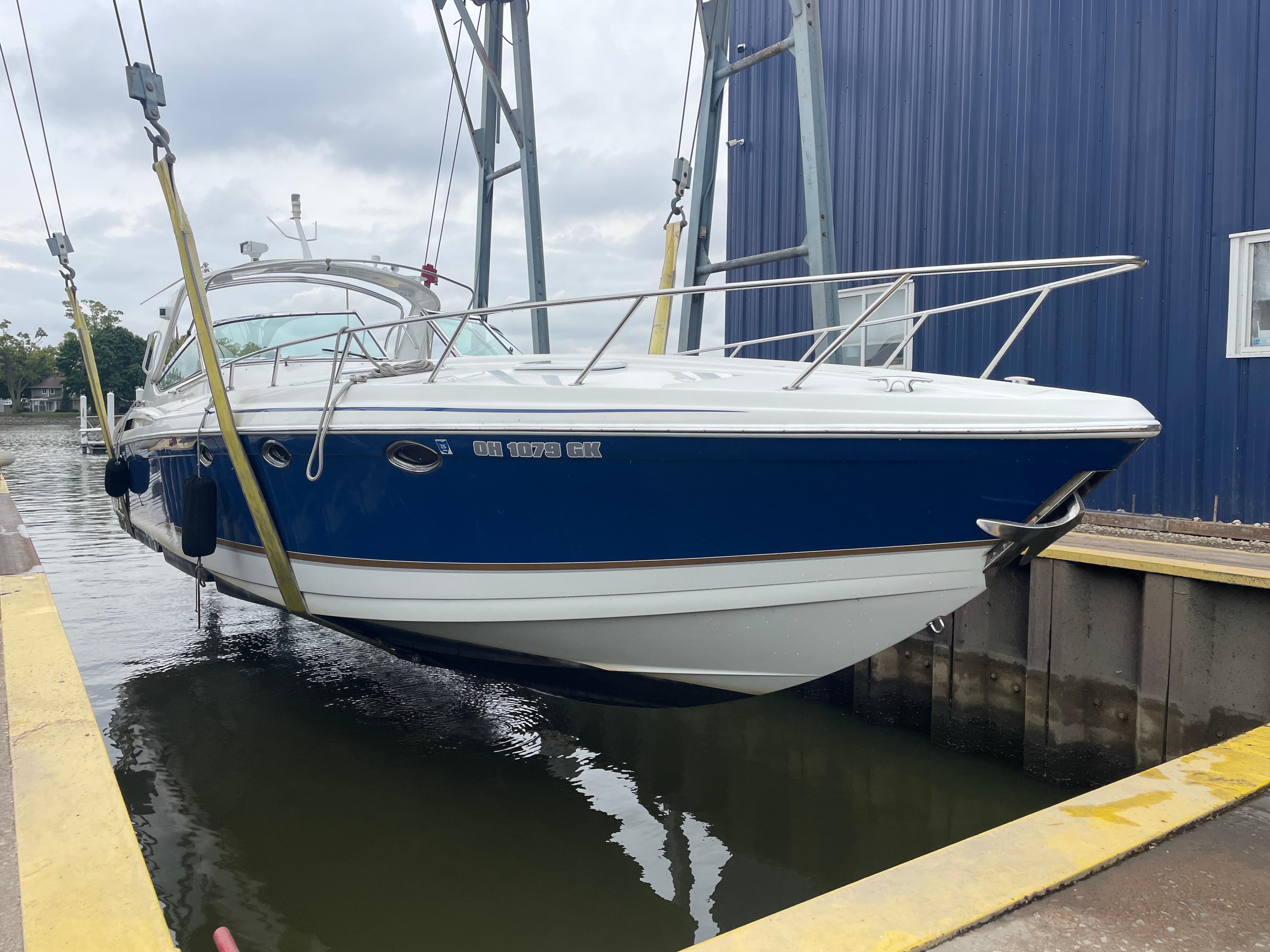 2002 Formula 400 Super Sport boat suspended by crane near water.