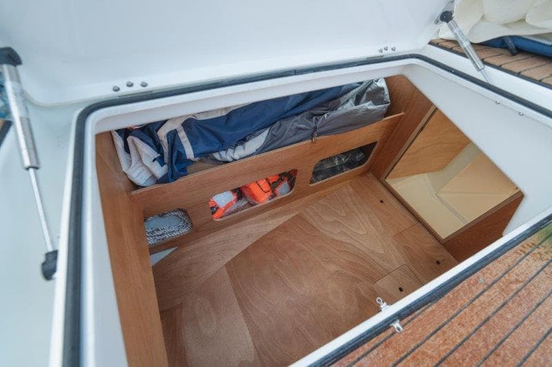Storage compartment in 2025 Jeanneau Sun Odyssey 350 sailboat, featuring organized space and wooden finish.