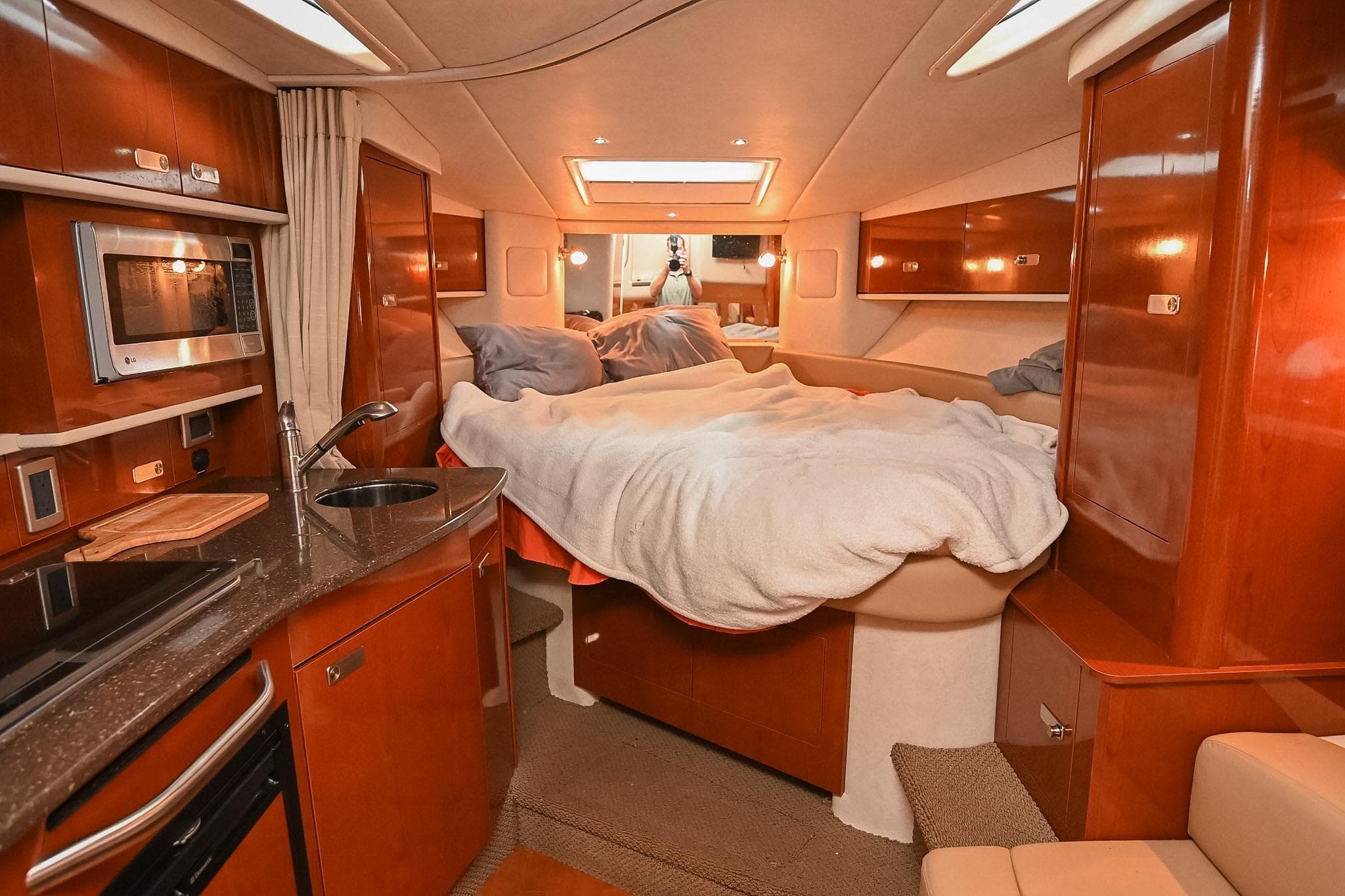 Luxurious 2012 Sea Ray Sundancer 330 cabin interior with bed and kitchenette.