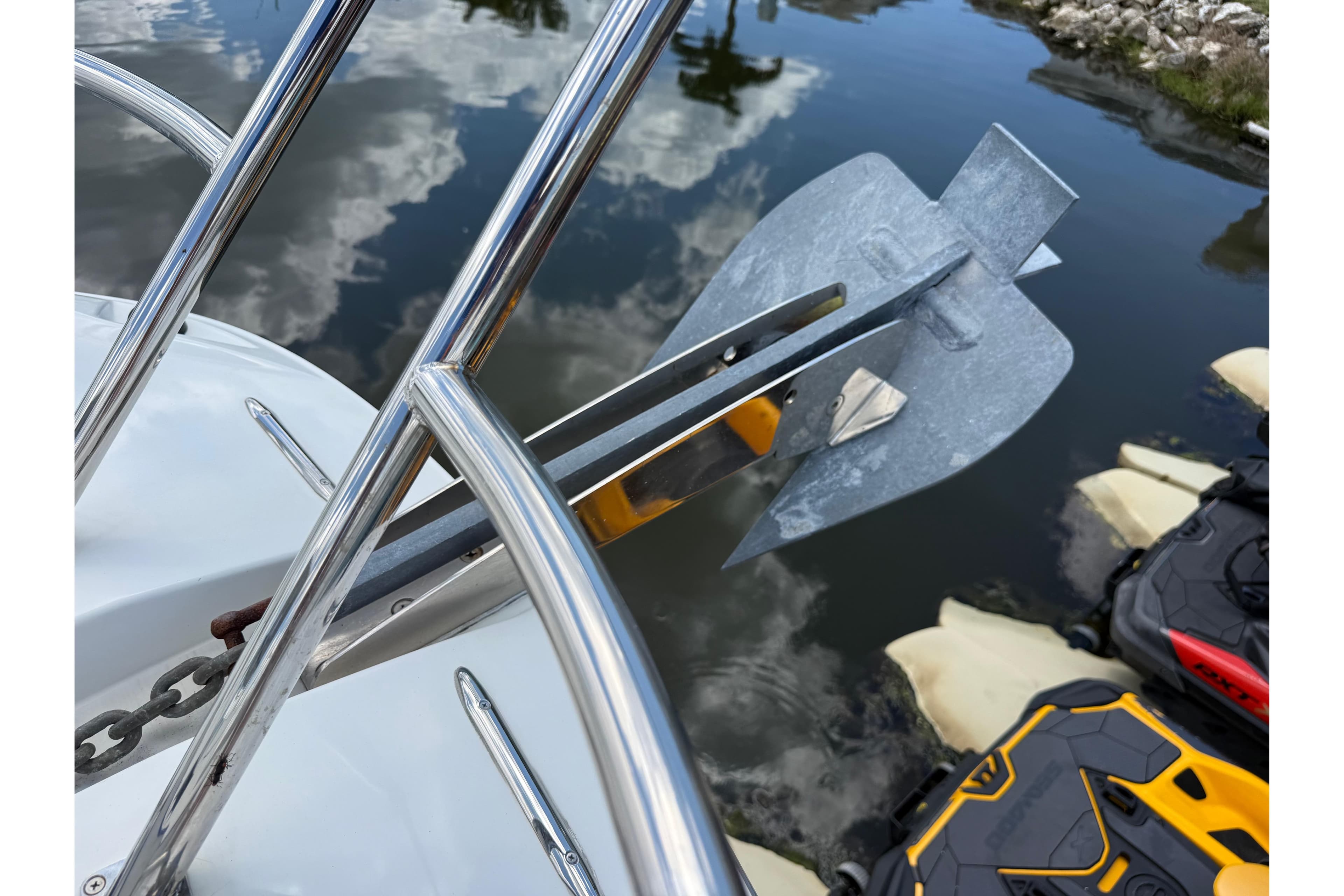 Anchor on Jeanneau Leader 10.5 boat, 2019 model, reflecting in calm water.