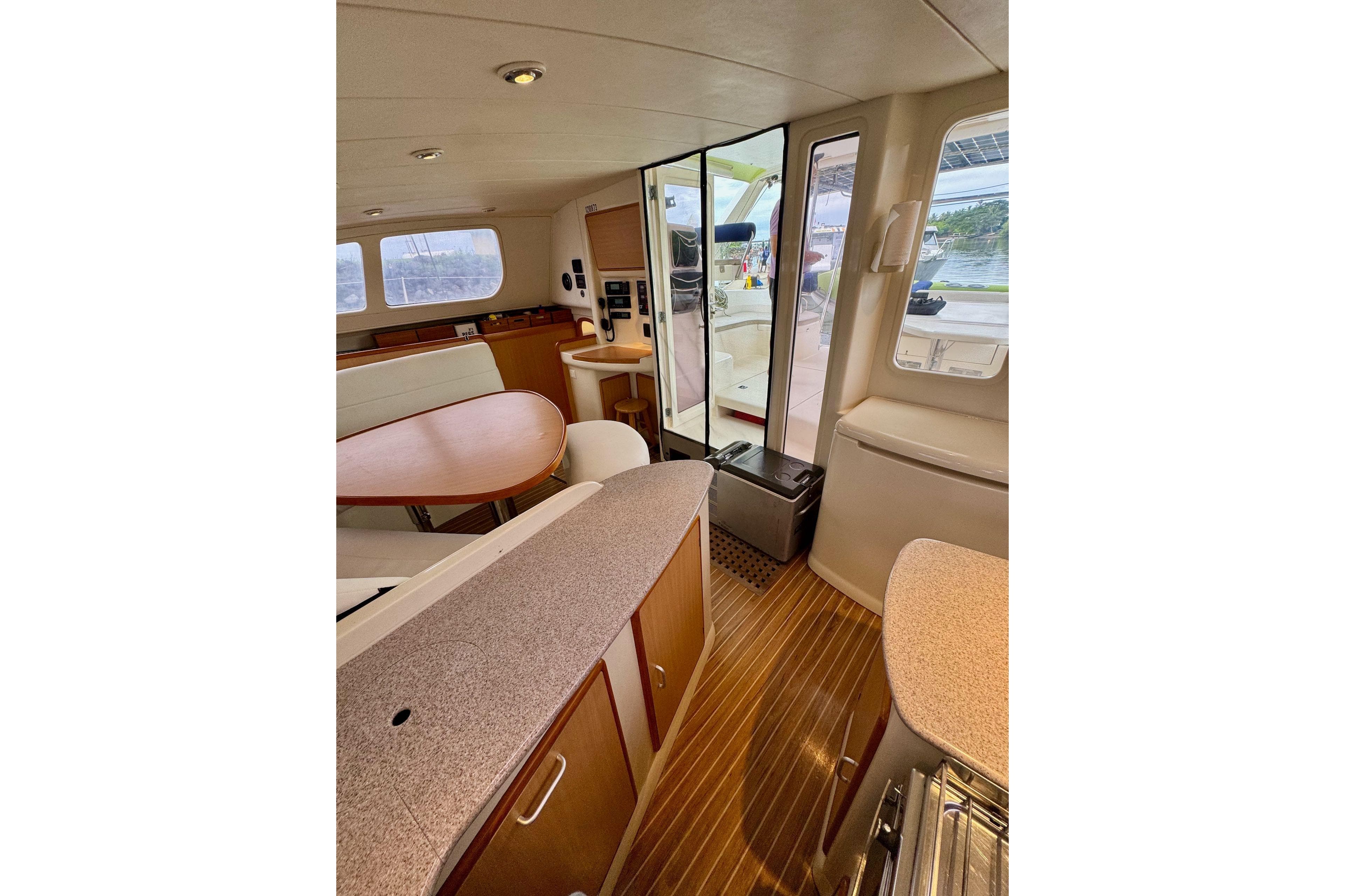 Interior of 2004 Leopard 42 yacht with modern design and wooden flooring.