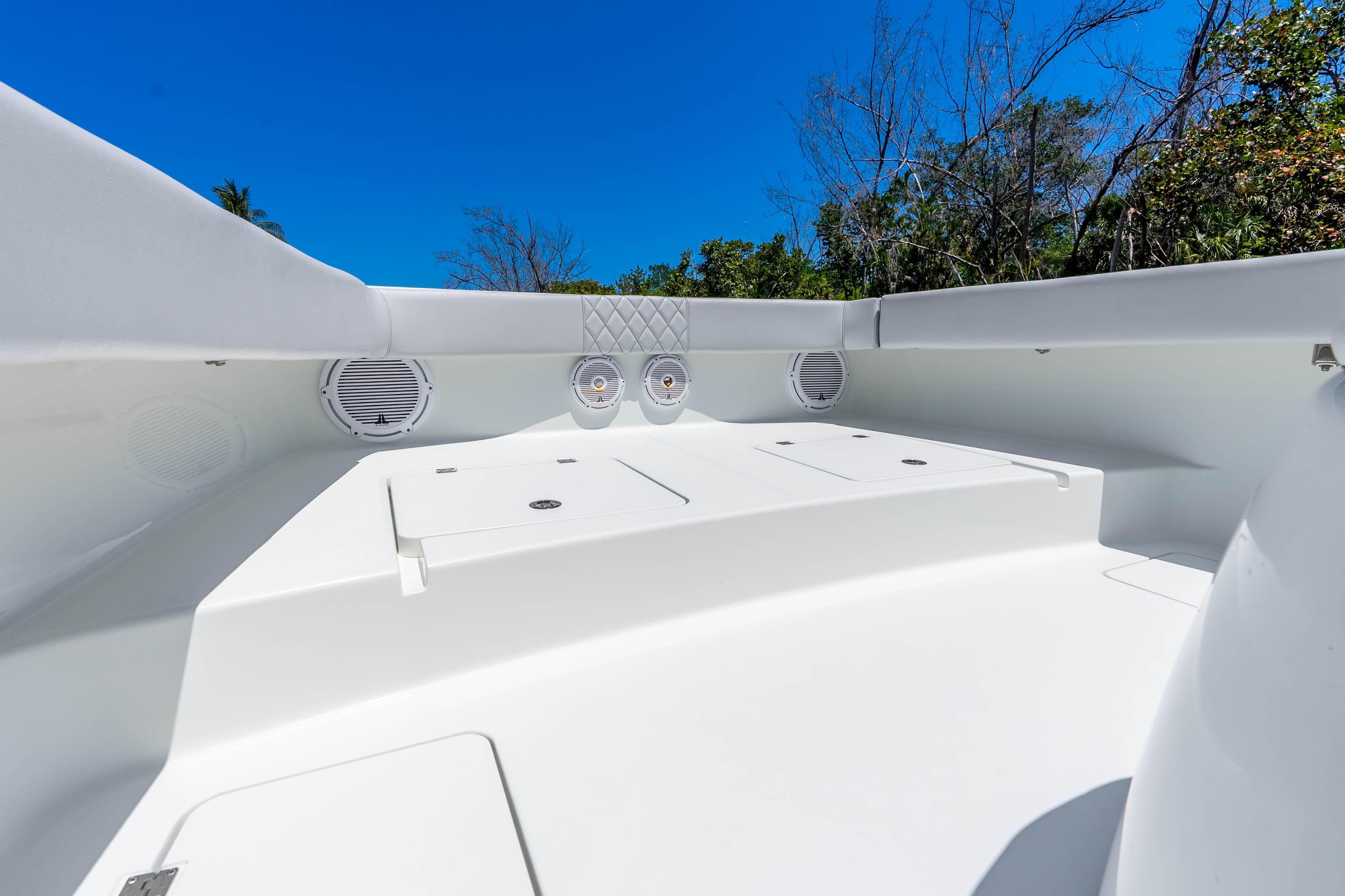 2019 Freeman 42LR boat interior with white seating and storage compartments under clear blue sky.