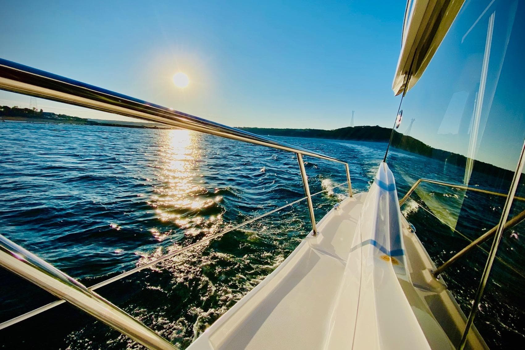 2018 Regal 42 Grande Coupe cruising on sunny waters, reflecting sunlight.
