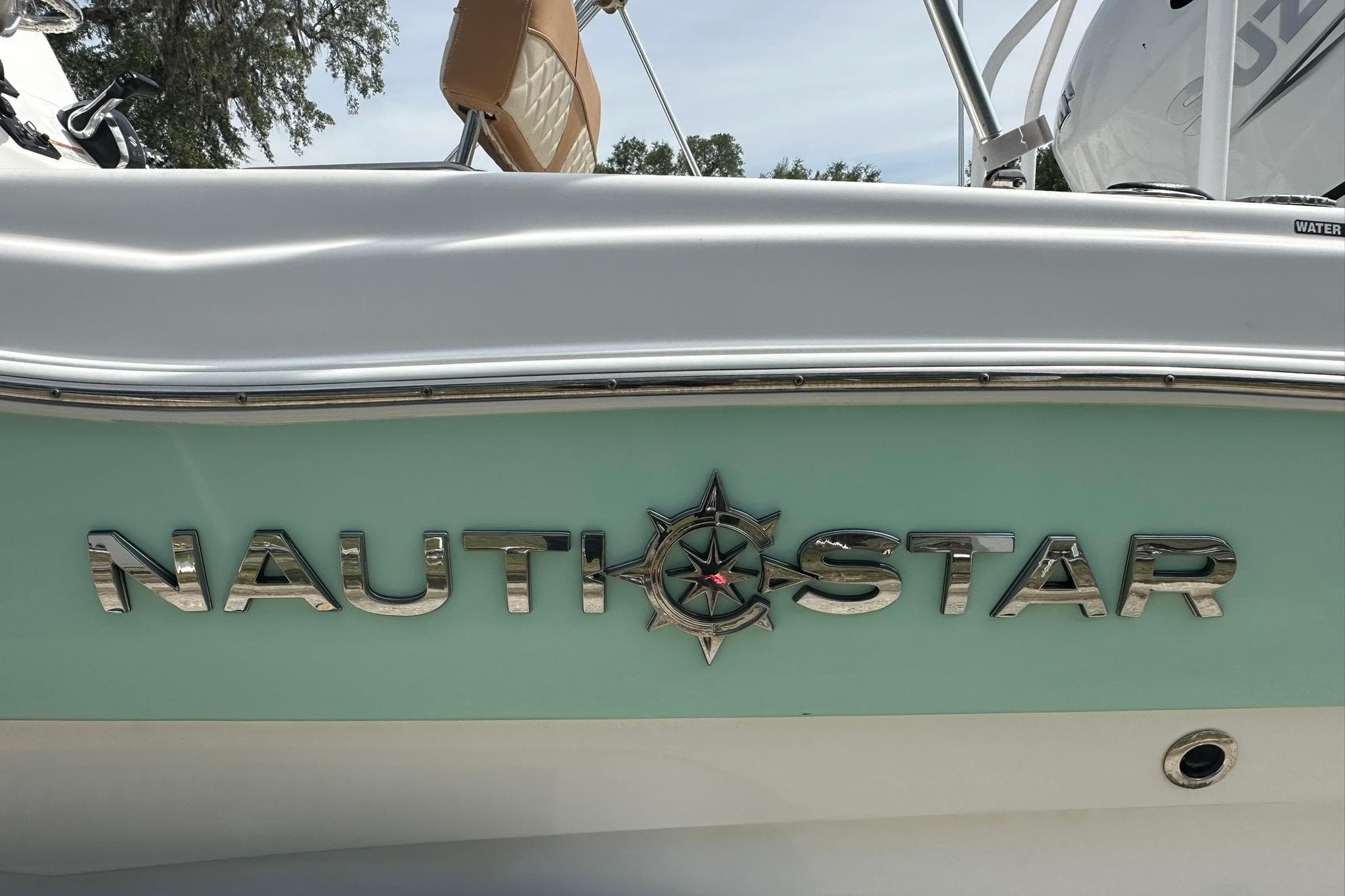 2024 NauticStar 211 Hybrid boat logo on a light green hull.