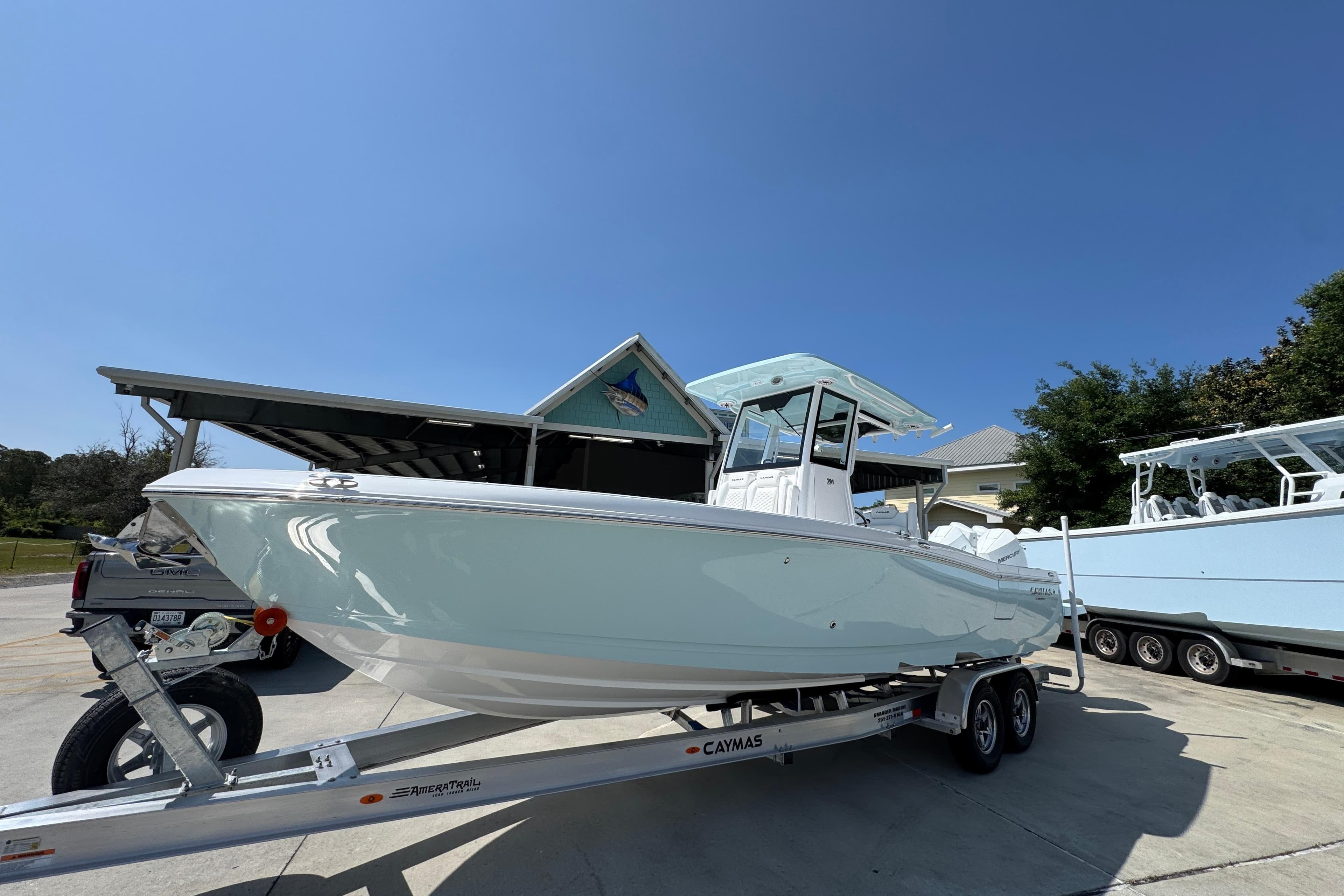 2026 Caymas 291 boat on trailer under clear blue sky.