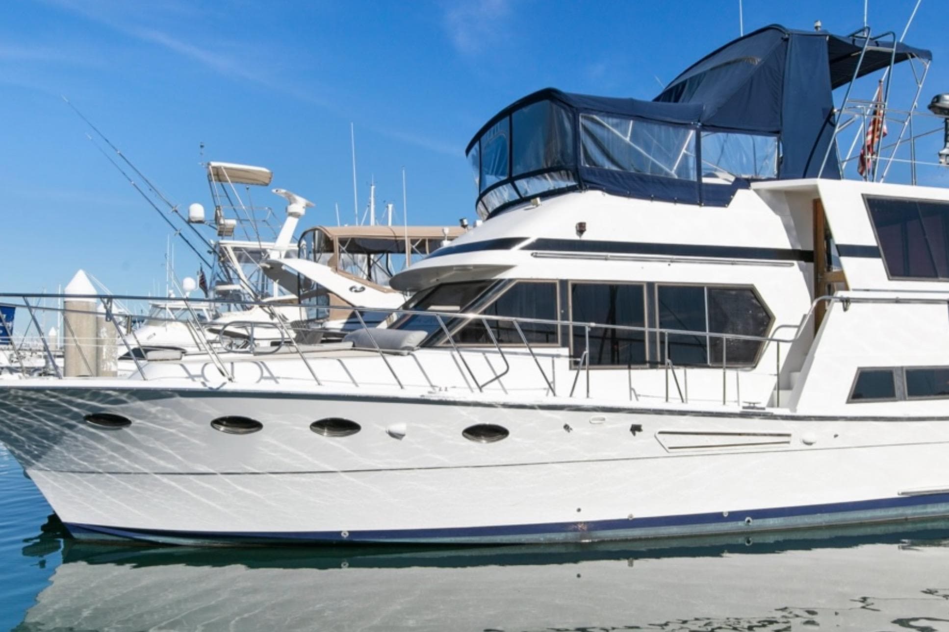 1989 Lien Hwa Vitesse Yachtfisher docked, featuring sleek design and spacious upper deck.