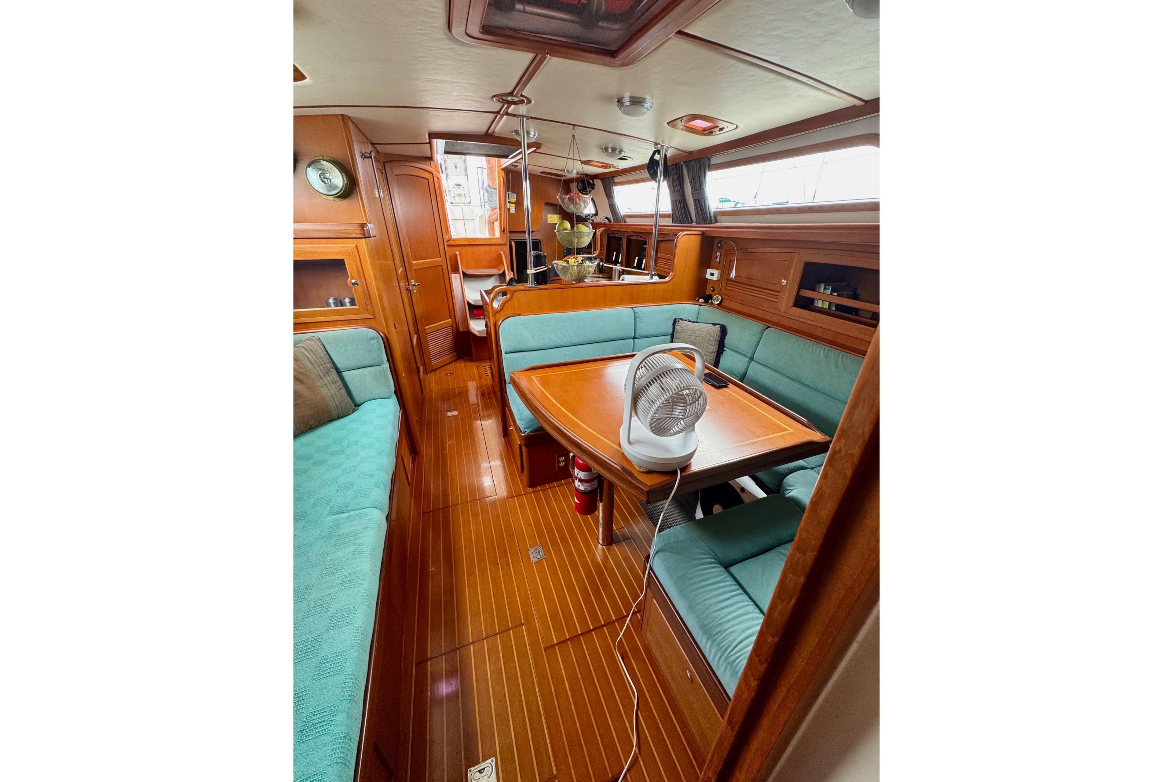 Interior of 2005 Outbound 46 yacht with wooden finish and teal seating.