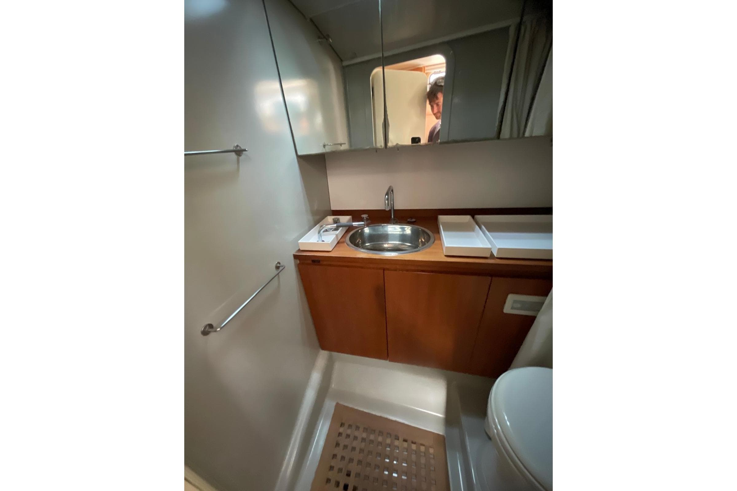 Bathroom interior of 2003 Maxi Dolphin 65 yacht with sink and wooden cabinetry.