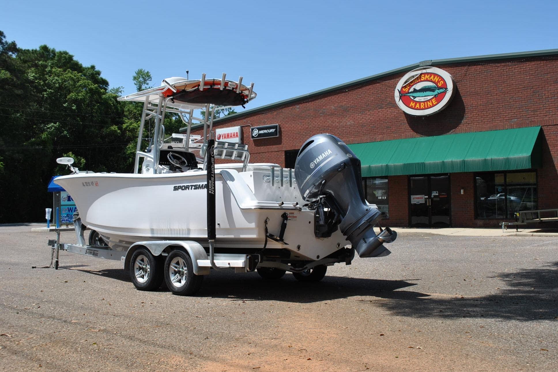 2020 Sportsman Open 232 Center Console boat on trailer outside marine store.