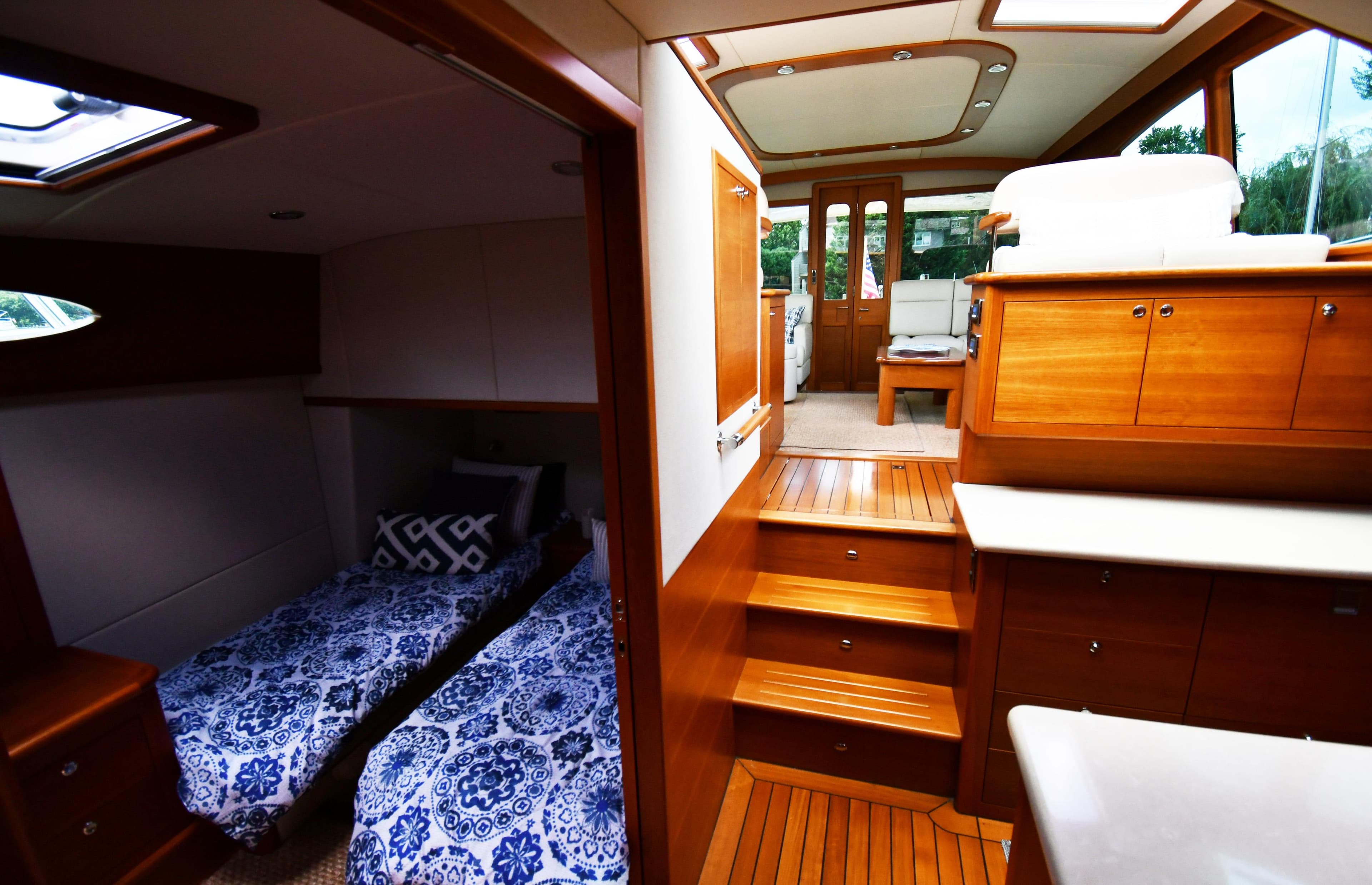 Luxurious interior of 2020 Palm Beach Motor Yachts PB52 with elegant wood finishes and twin beds.
