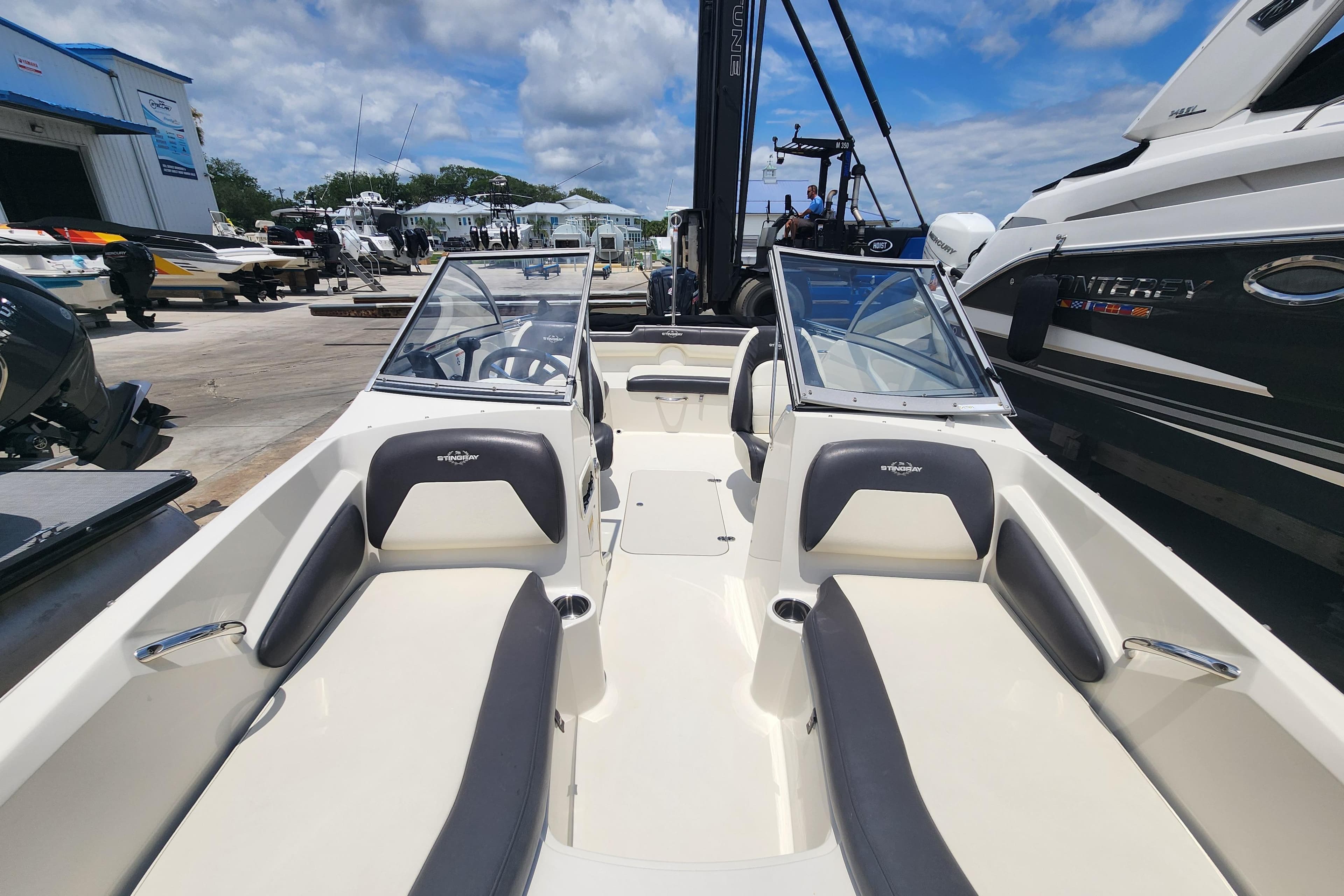 2018 Stingray 191 DC boat interior with seating, docked at marina under blue sky.