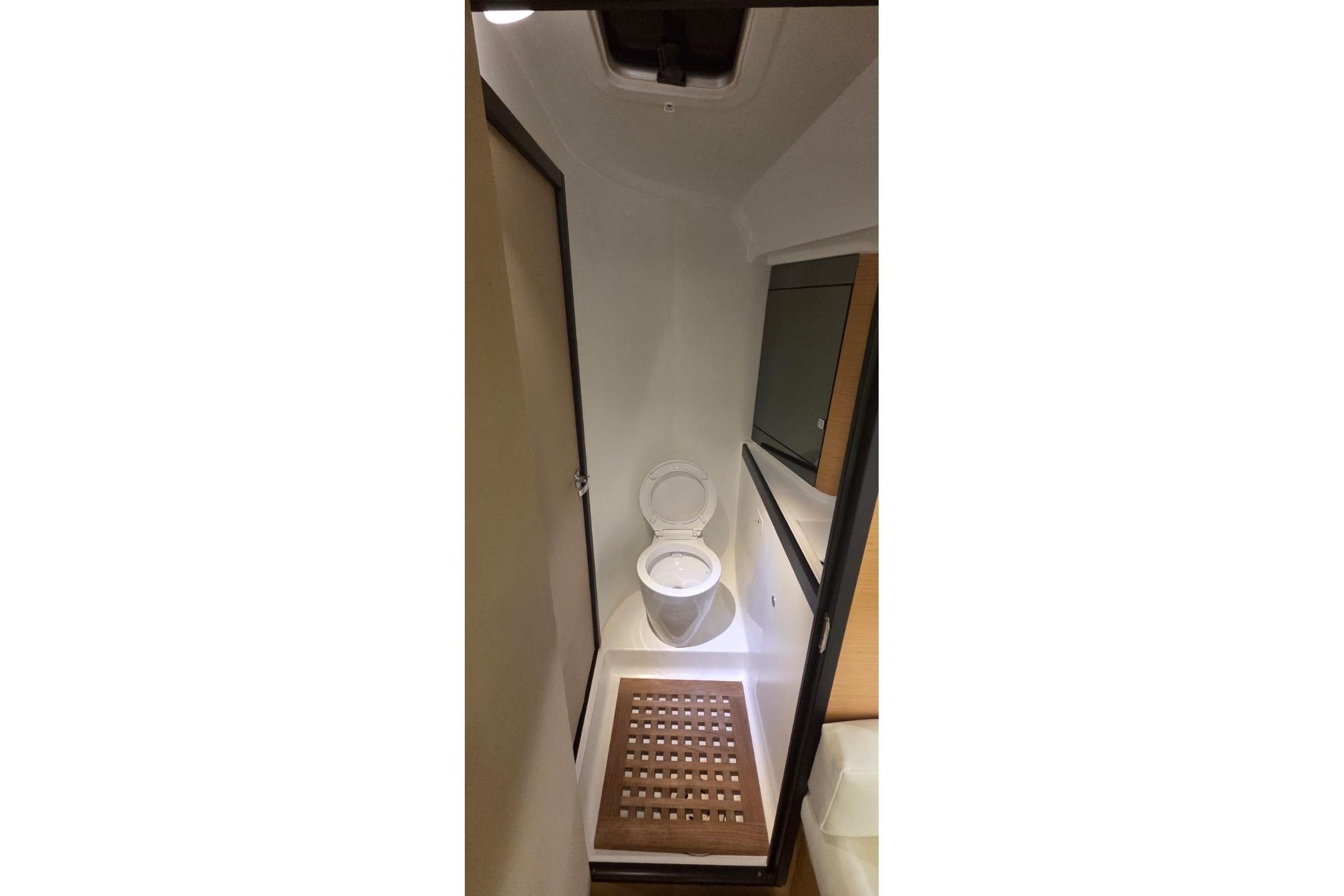 Bathroom interior of 2012 Beneteau First 40 yacht, featuring a toilet and wooden floor mat.