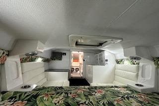 2021 Velocity 290 Sport Cruiser cabin with floral bedding and white seating.