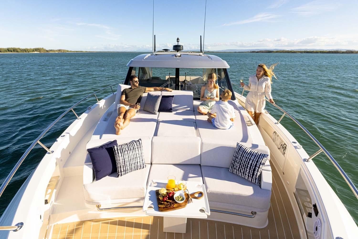 Manufacturer Provided Image: People relaxing on a 2026 Riviera 4300 Sport Express yacht, enjoying a sunny day at sea.