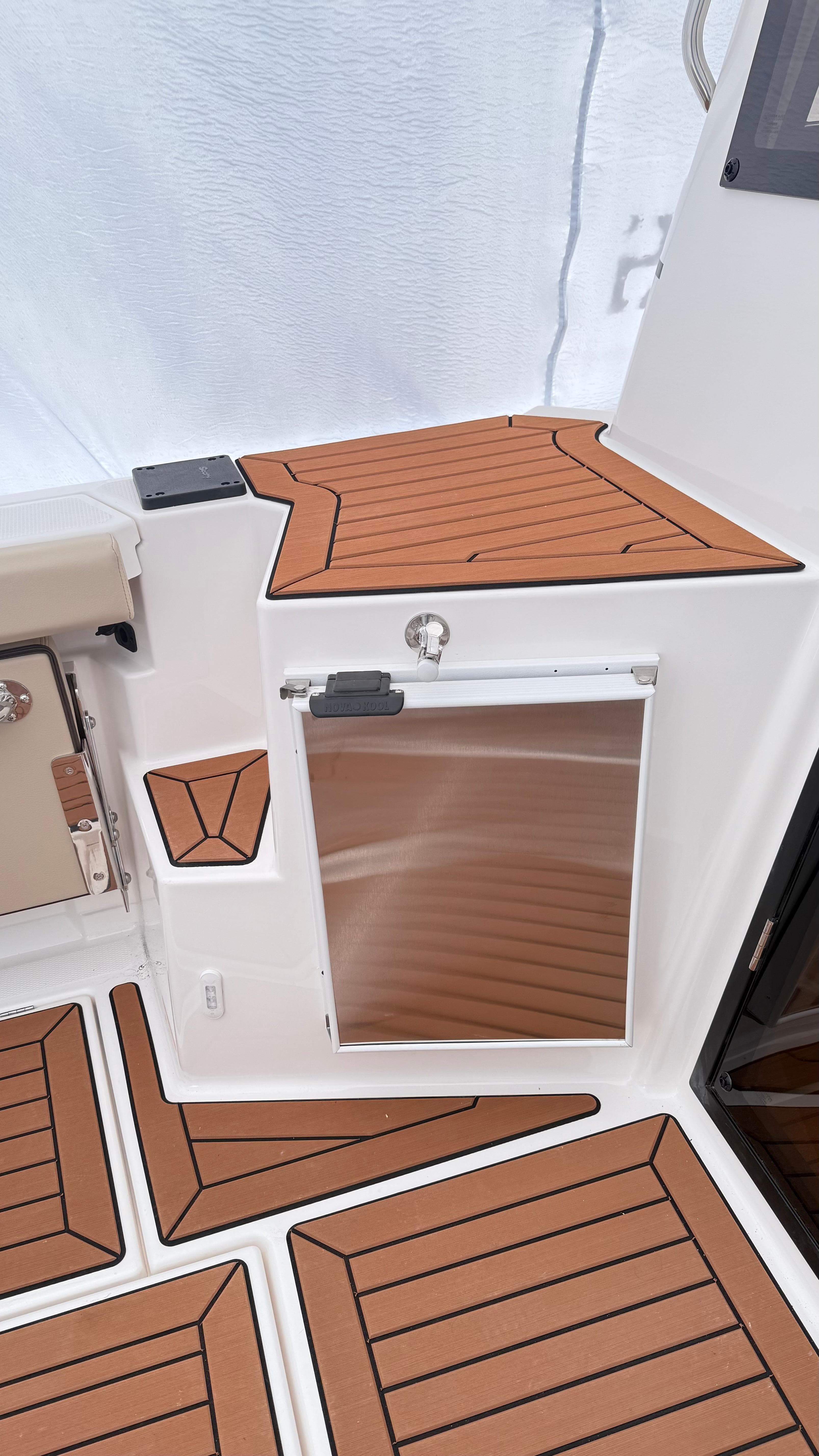 2026 Ranger Tugs R-27 boat interior with wood-patterned flooring and stainless steel features.