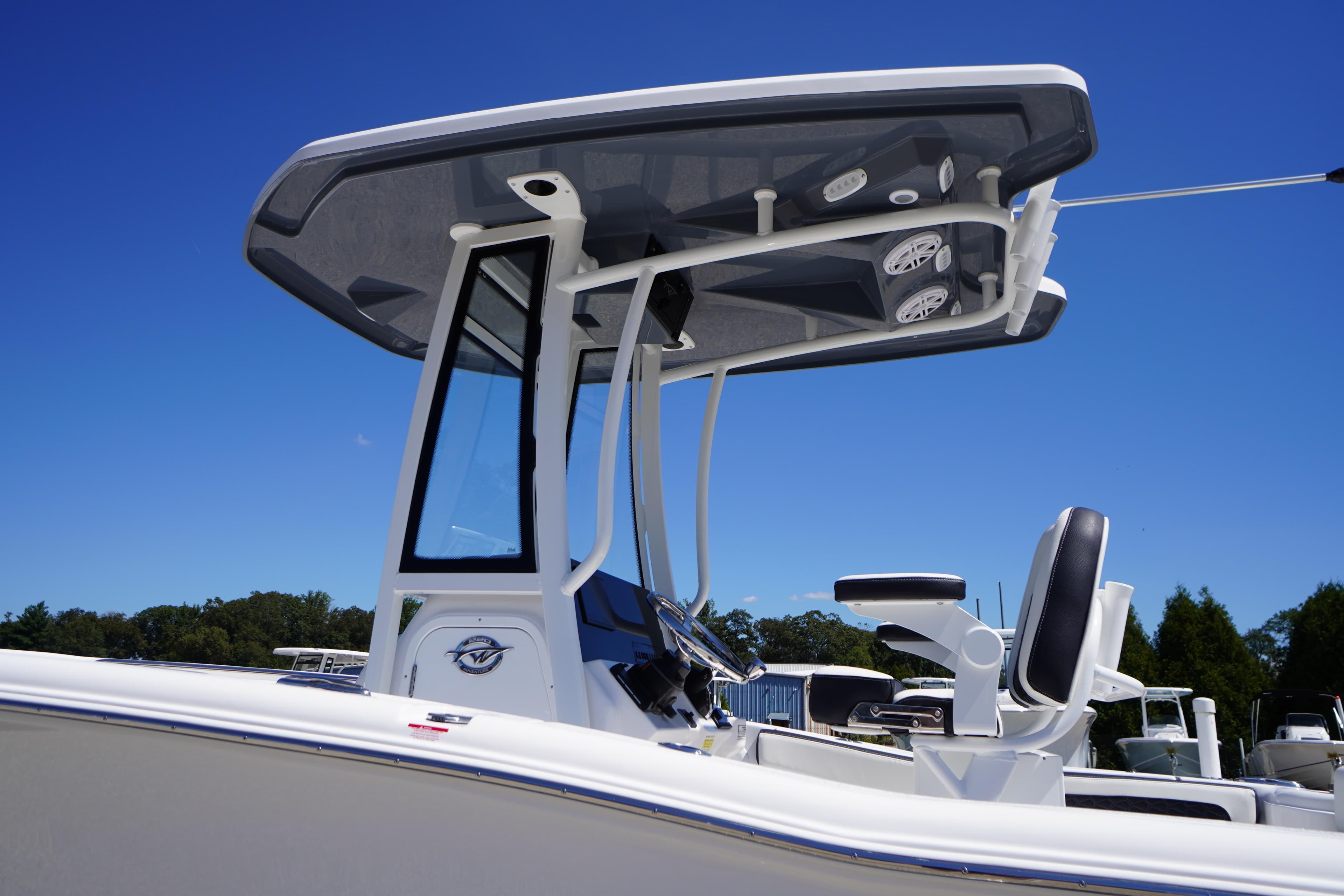 2026 Tidewater 220 CC Adventure boat with T-top and seating, under clear blue sky.