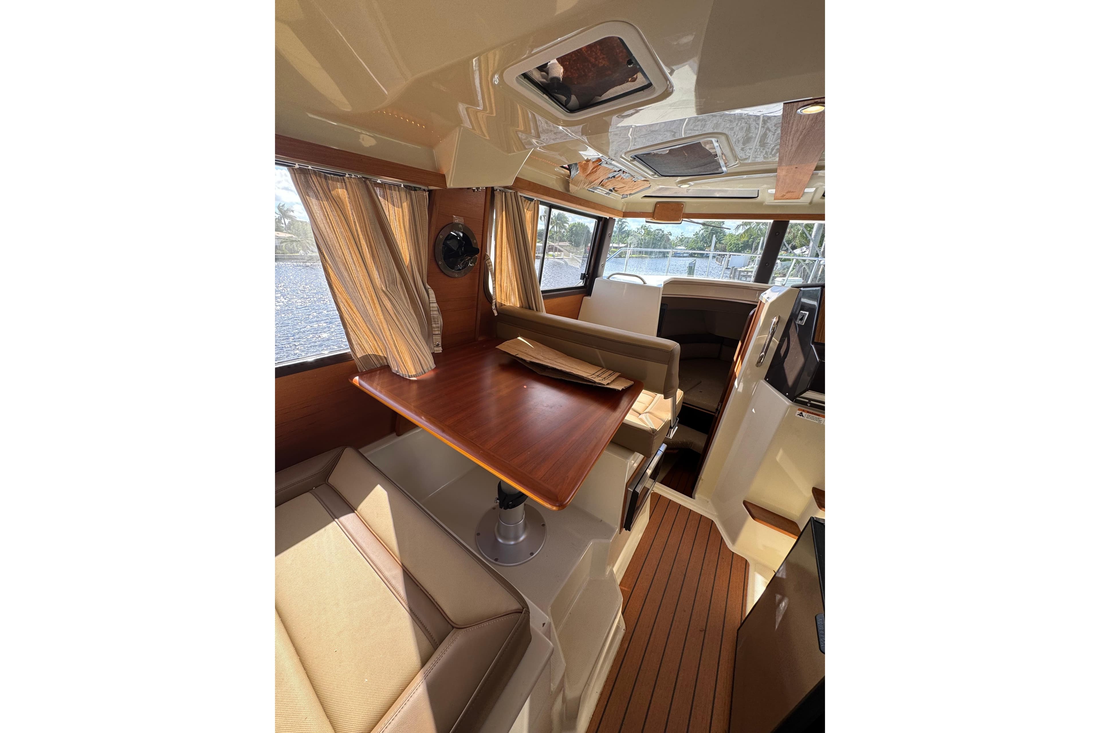 Interior of 2021 Ranger Tugs R-25, featuring a cozy dining area with wood accents.