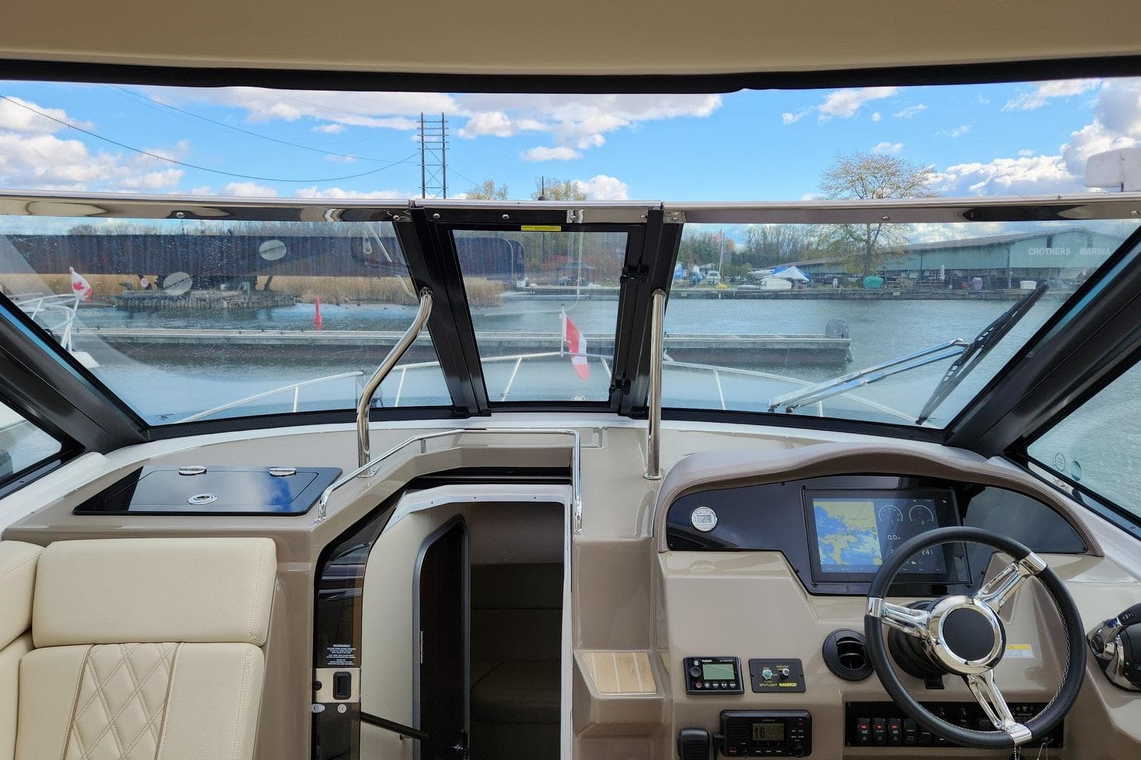 2018 Regal 35 Sport Coupe cockpit with steering wheel, navigation system, and waterfront view.