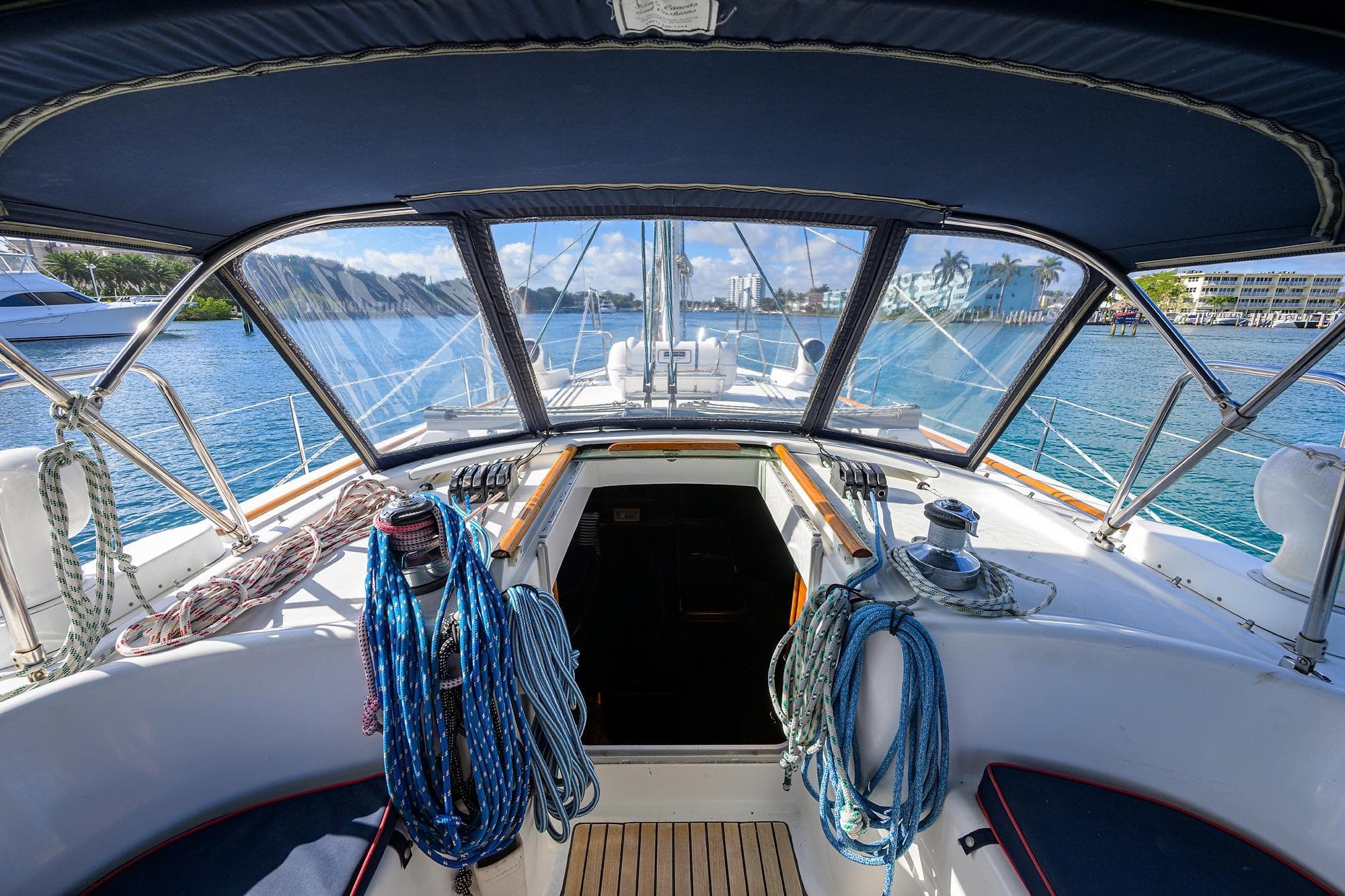 Cockpit view of 2003 Beneteau 50 sailboat with ropes and marina backdrop.