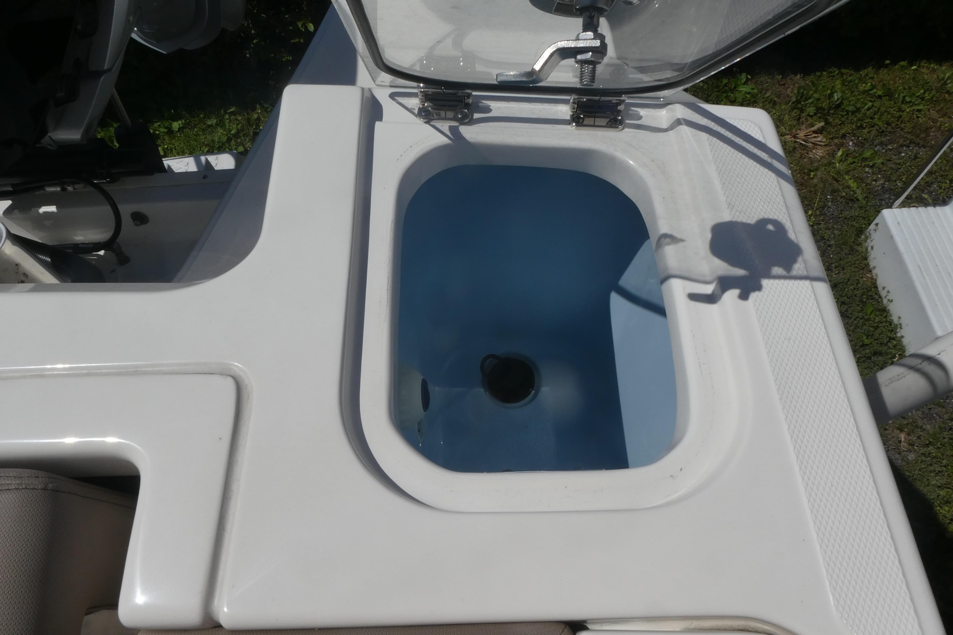 Livewell on a 2026 Boston Whaler 240 Vantage boat, open lid, sunny day.