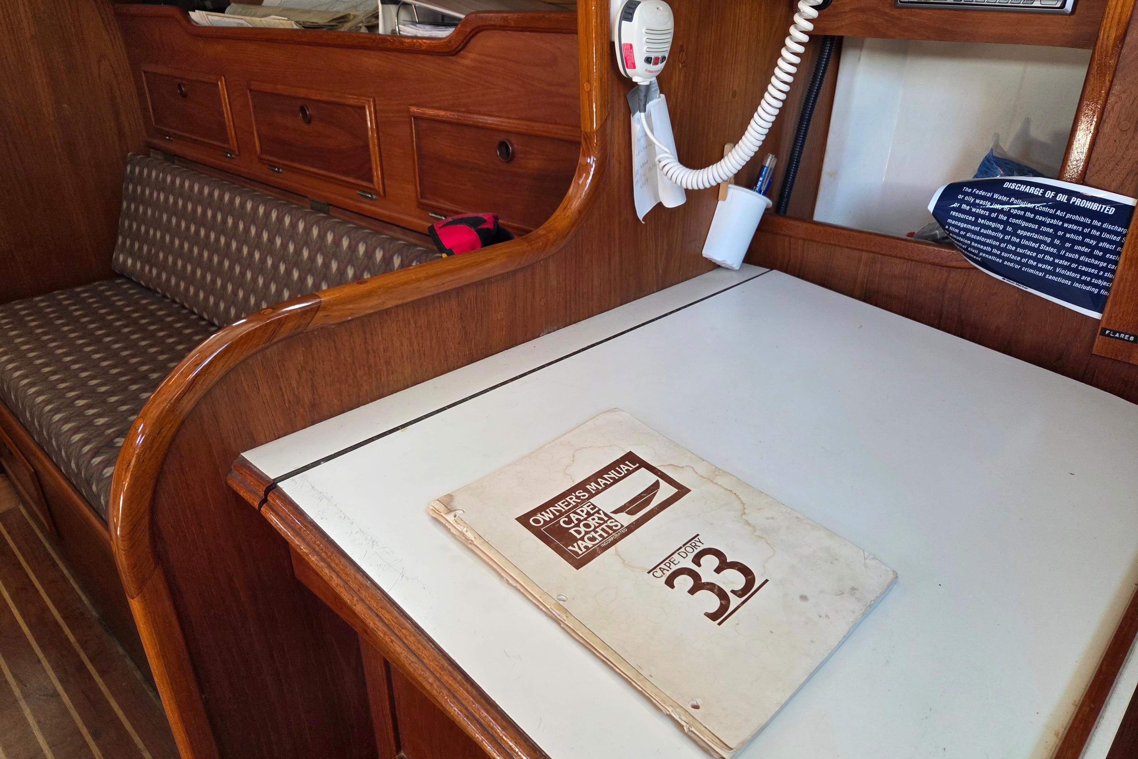 Interior of 1982 Cape Dory 33 yacht with owner's manual on table.