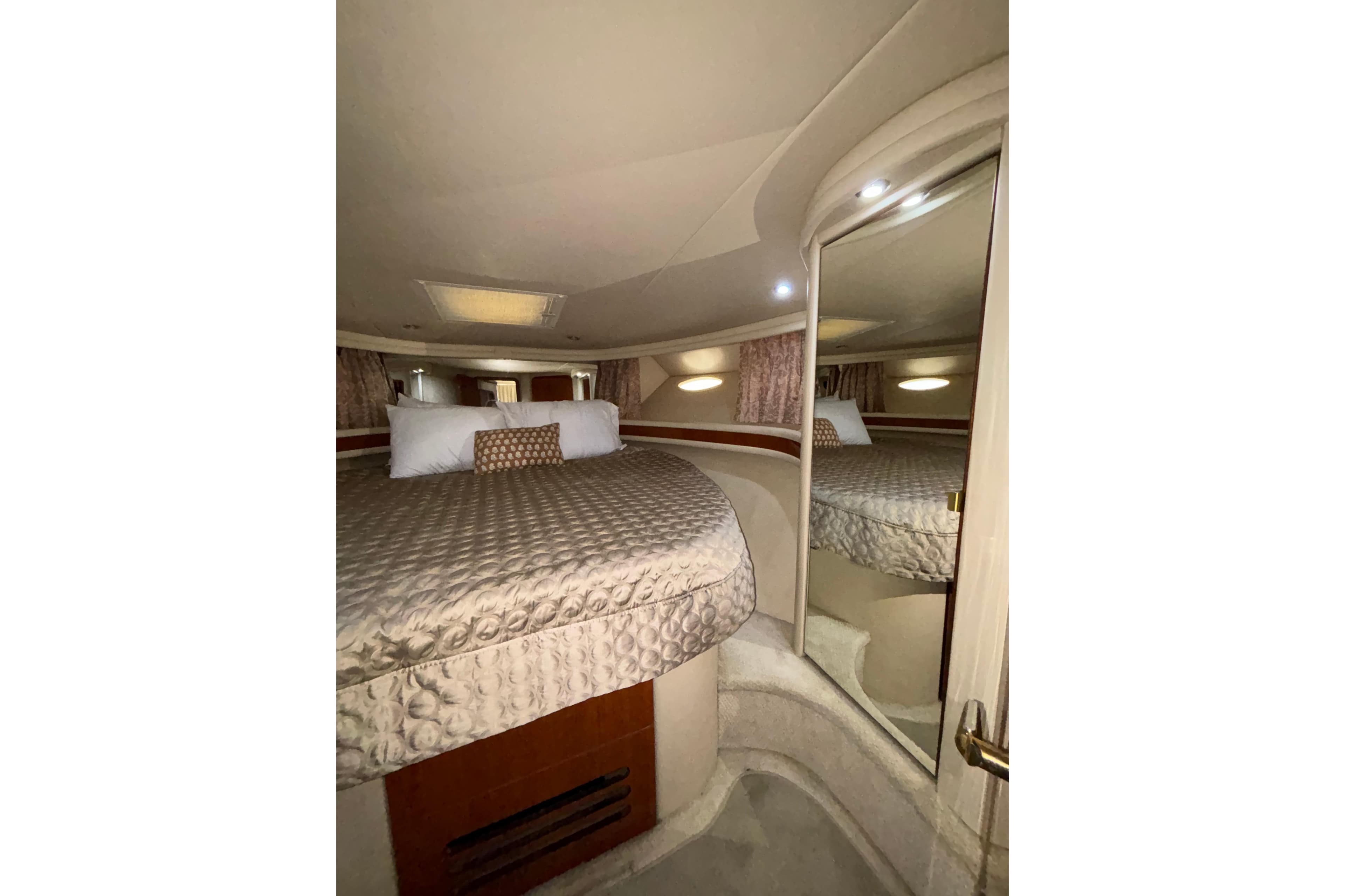 Luxurious bedroom interior of 1999 Sea Ray 480 Sedan Bridge yacht with elegant bedding.