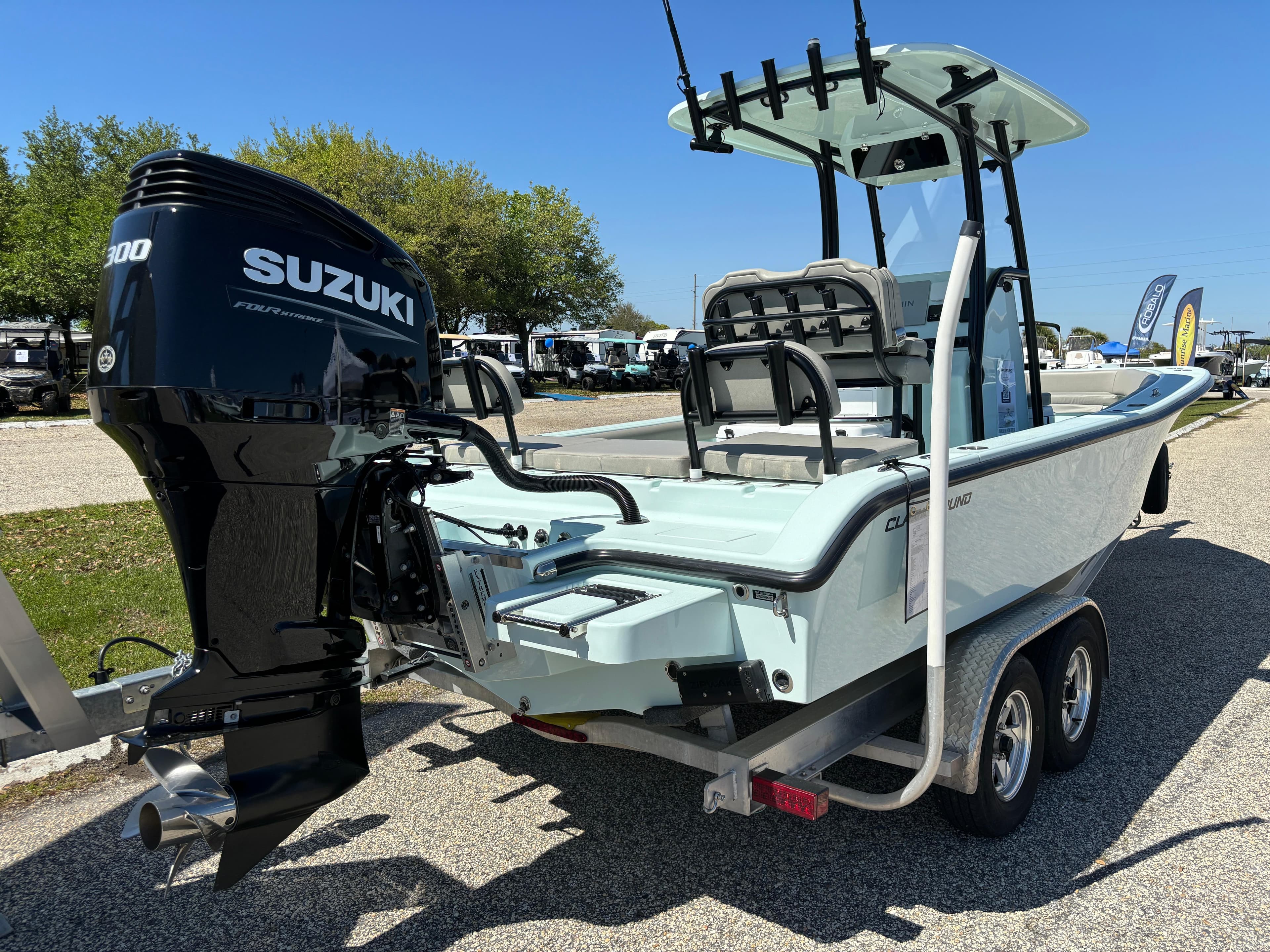 2024 Clark Sound 24 boat with Suzuki engine on a trailer, parked outdoors.